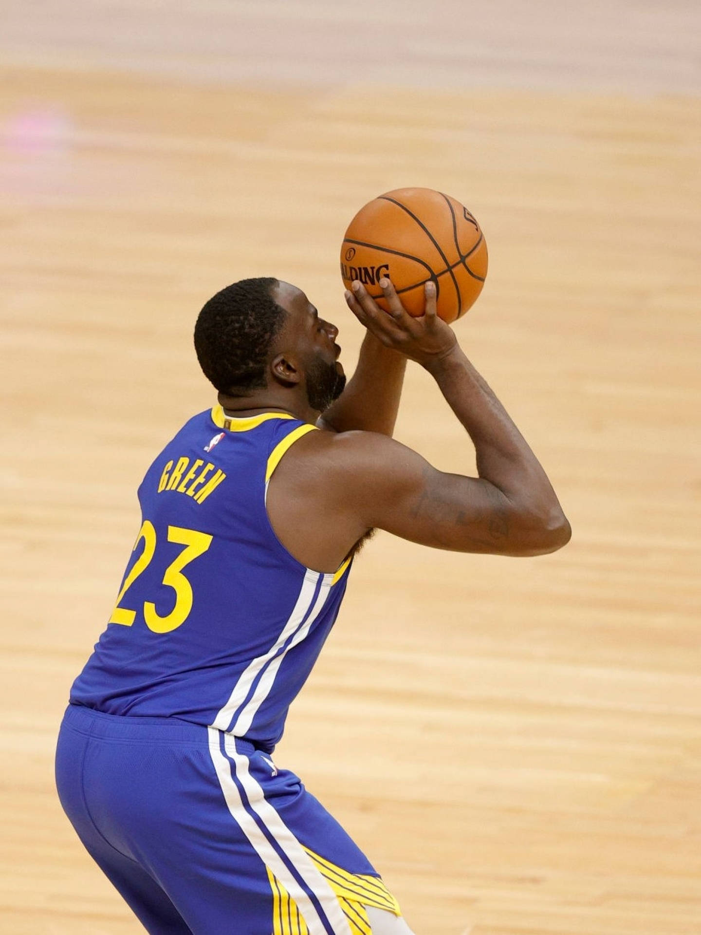 Draymond Green 桌布 壁紙 — 一名身穿藍黃色球衣的籃球運動員在木地板上準備投籃。