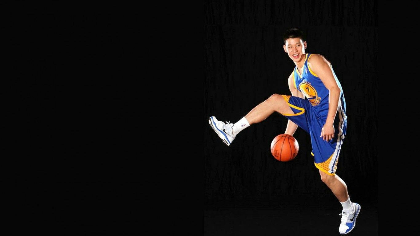 NBA 桌布 壁紙 — 一名身穿藍黃色球衣的籃球運動員在黑色背景下微笑，同時將球平衡在膝蓋上。
