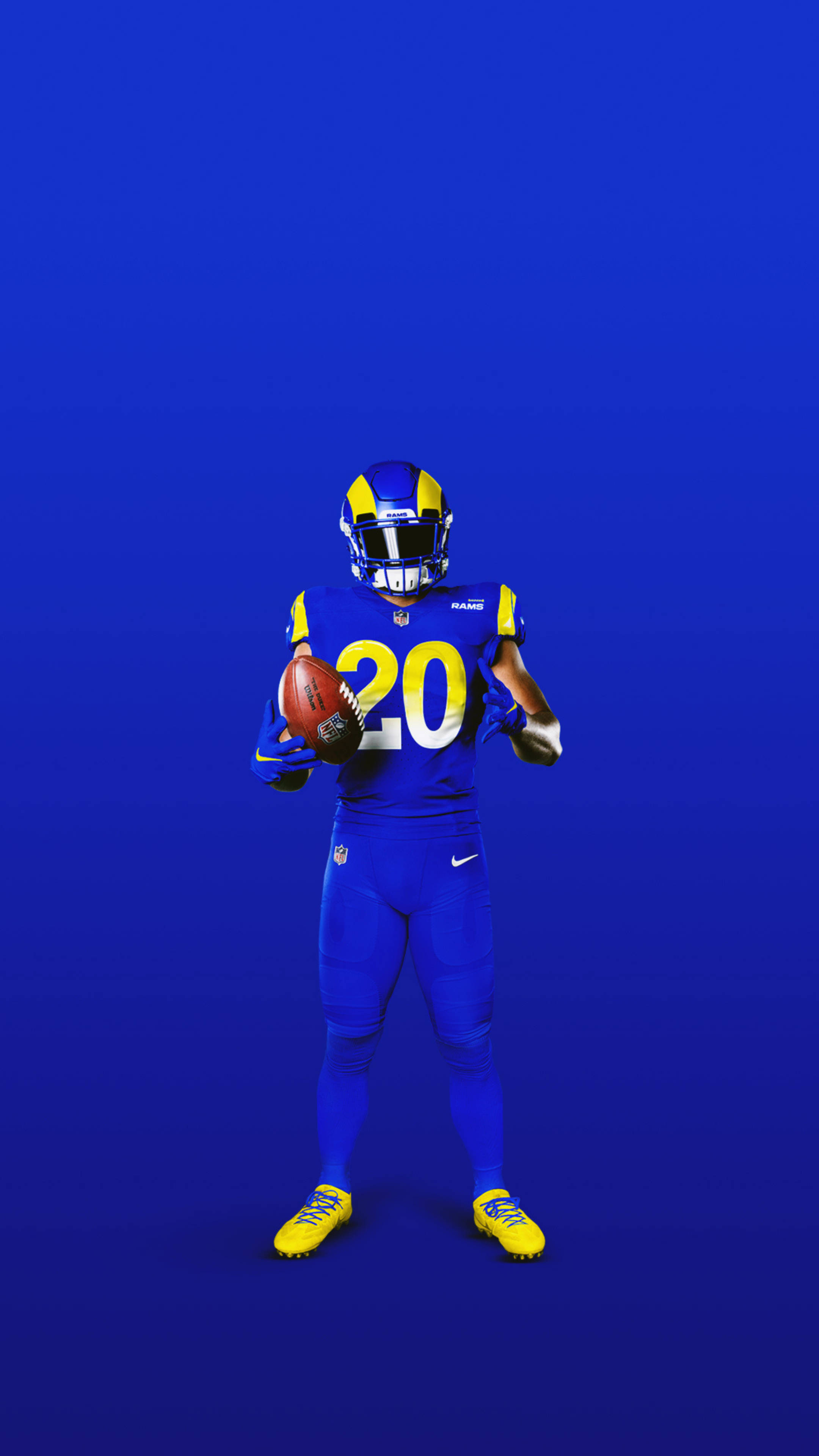 Rams 桌布 壁紙 — 一名身穿藍黃色球衣的足球運動員在純藍色背景前持球。
