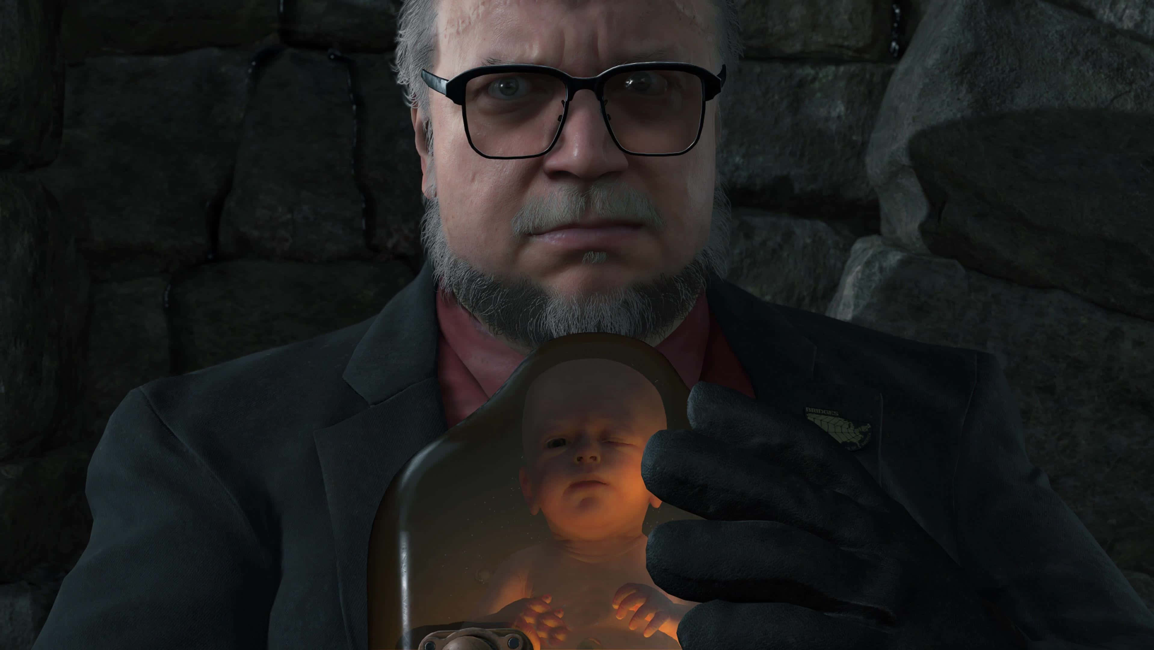 death stranding iPhone 桌布 壁紙 — 一名身穿西裝、戴眼鏡的男子在昏暗的石牆房間裡，手持一個發光的玻璃罩，裡面有一個嬰兒。