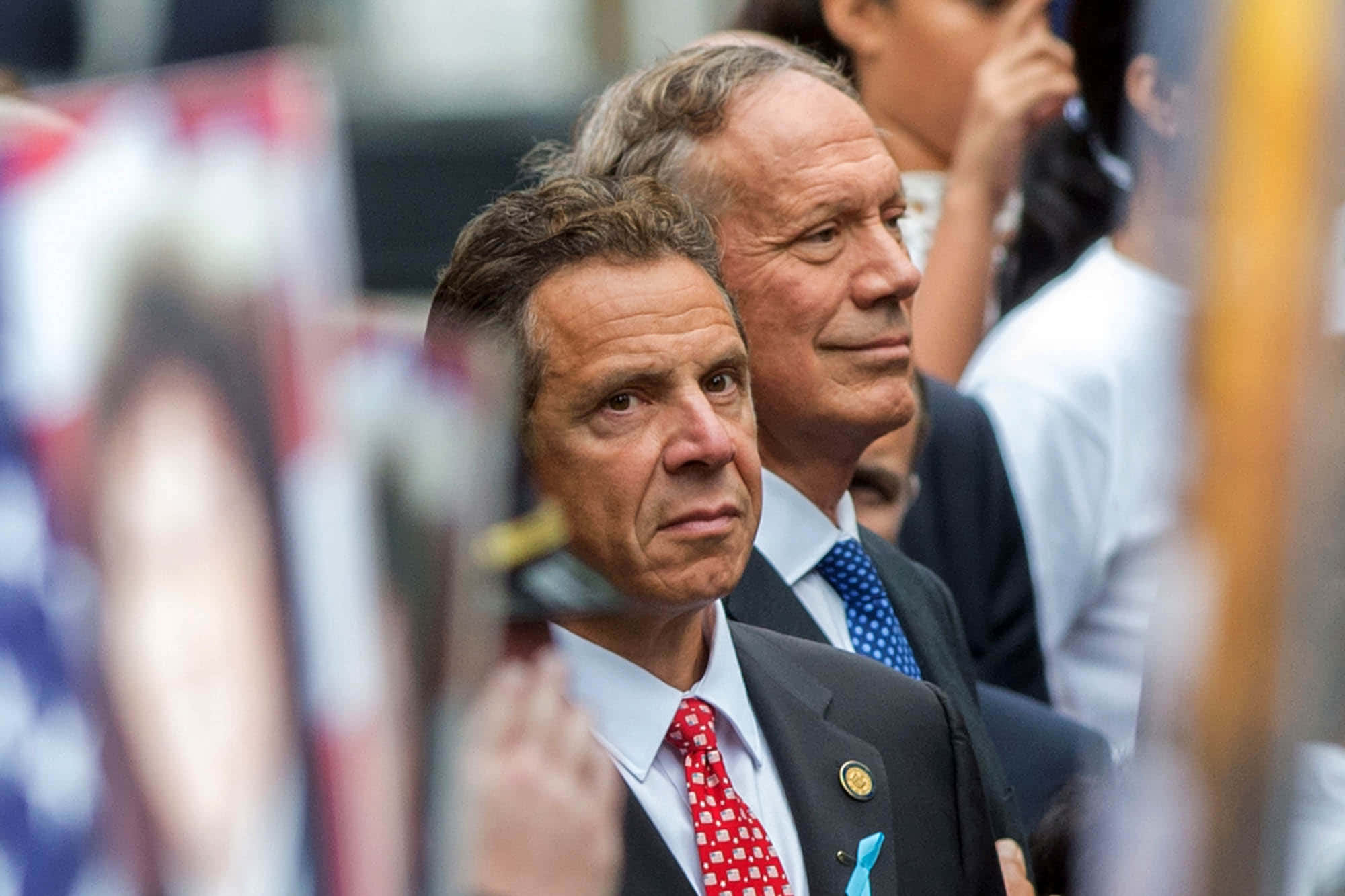 smiling 桌布 壁紙 — 一名身穿西裝、繫著紅色圖案領帶的男士，神情嚴肅地專注向前看的特寫照片。