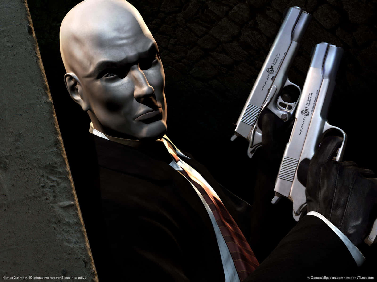 Hitman 2 桌布 壁紙 — 一名身穿西裝的光頭刺客，在戲劇性的燈光下，手持兩把銀色手槍，背靠深色石牆。