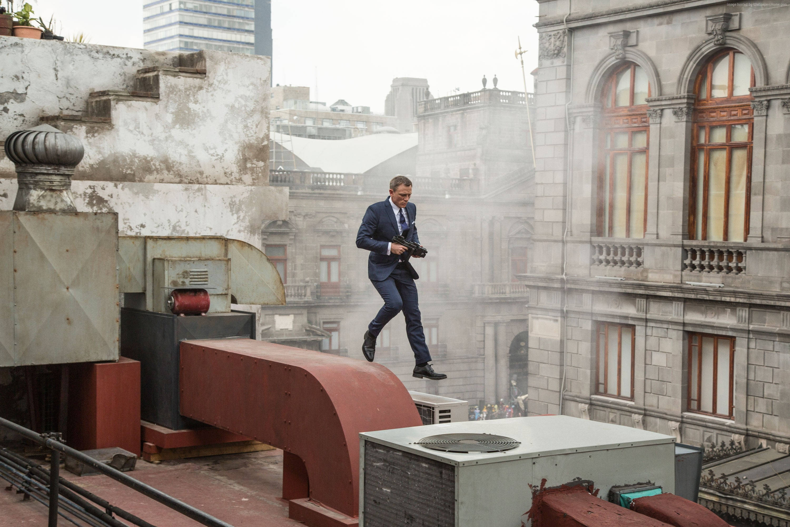 Daniel Craig 桌布 壁紙 — 一名身穿西裝的男子在霧中跑過屋頂，背景是歷史建築。
