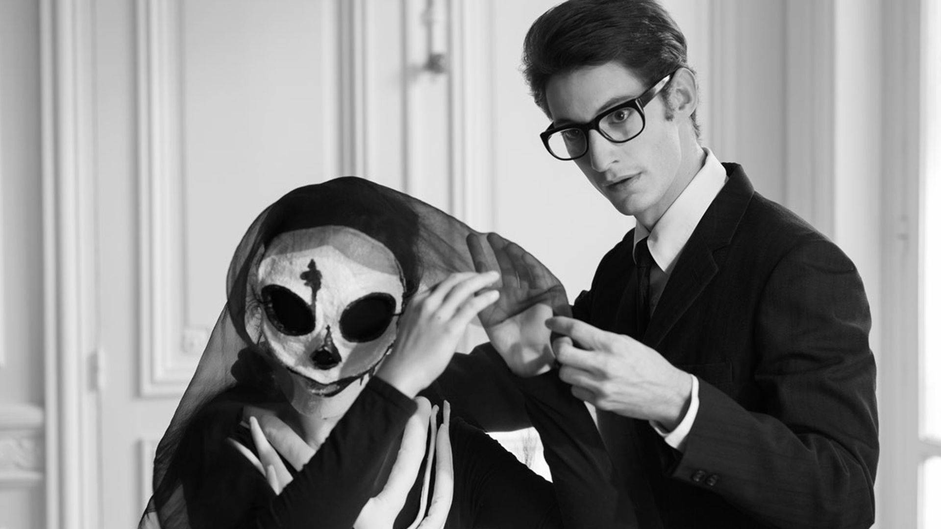 Ysl 桌布 壁紙 — 一名身穿西裝的男子在黑白鮮明的肖像中調整覆蓋在戴著骷髏面具的人身上的面紗。