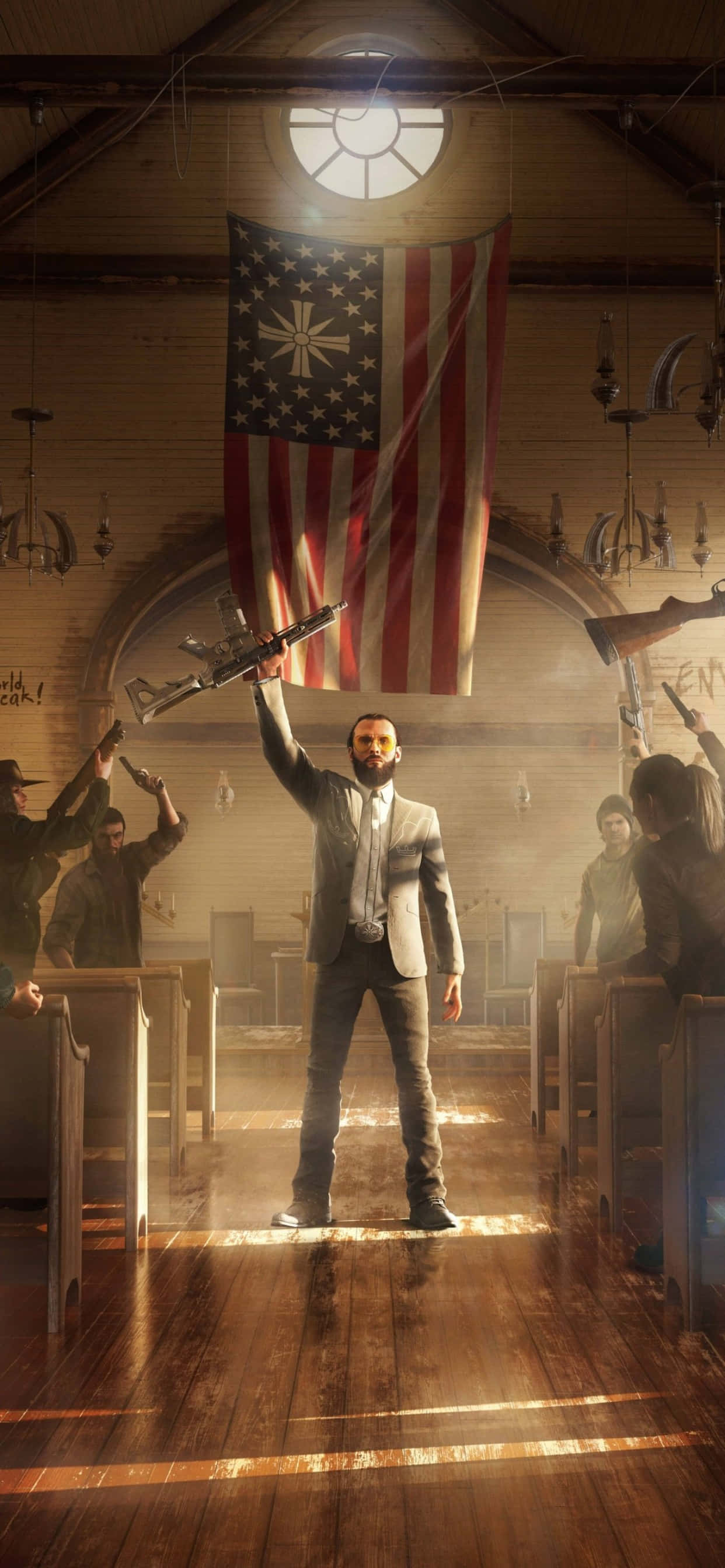 iPhone Xs Max Far Cry 5 桌布 壁紙 — 一名身穿西裝的男子挑釁地站在木製教堂走廊上，手持步槍，被頭頂一盞燈照亮，身後掛著一面帶有十字架的美國國旗。