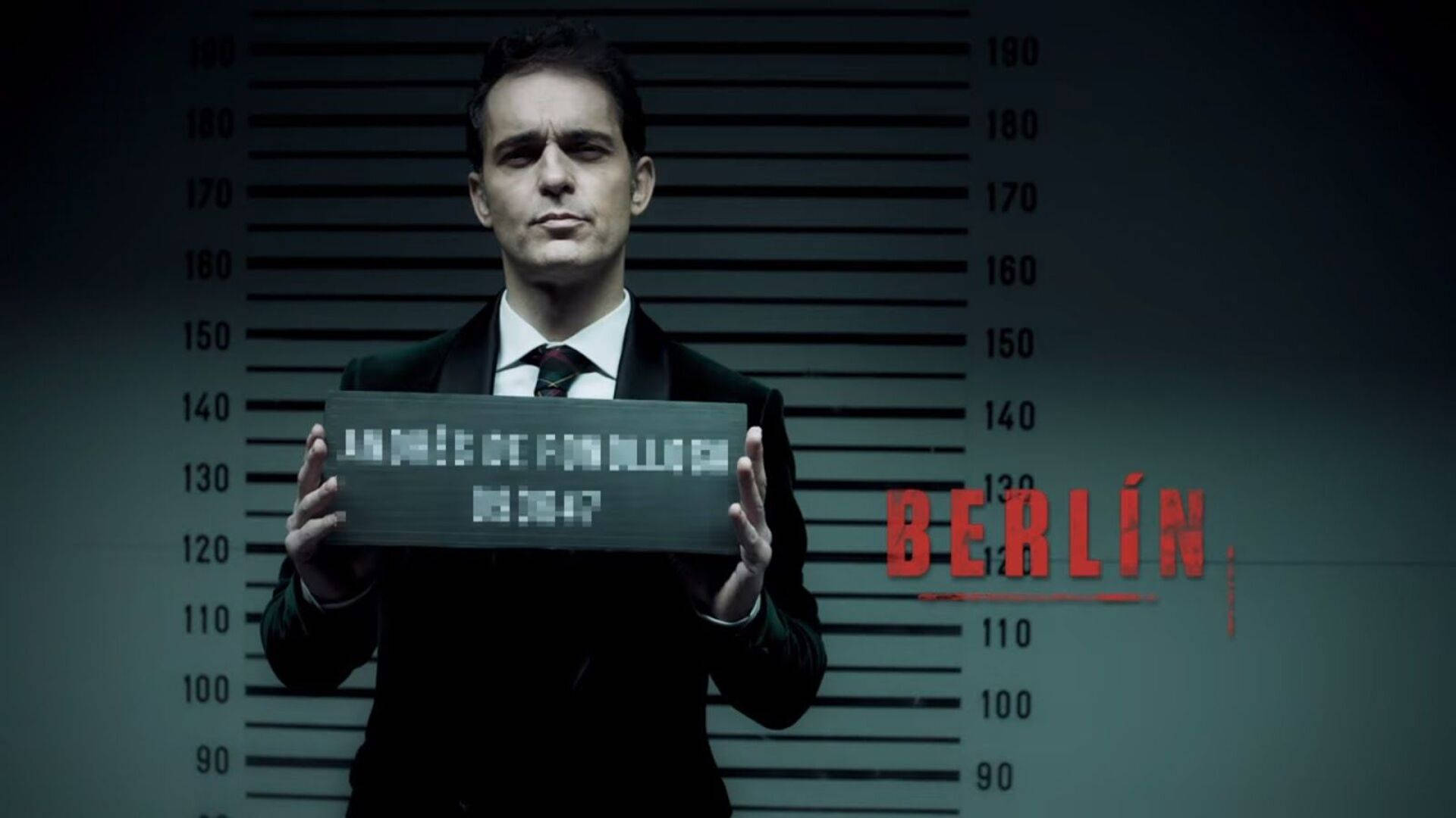 Berlin Money Heist 桌布 壁紙 — 一名身穿西裝的男子站在警察身高圖前，旁邊拿著一個帶有紅色文字「BERLÍN」的像素化標誌。
