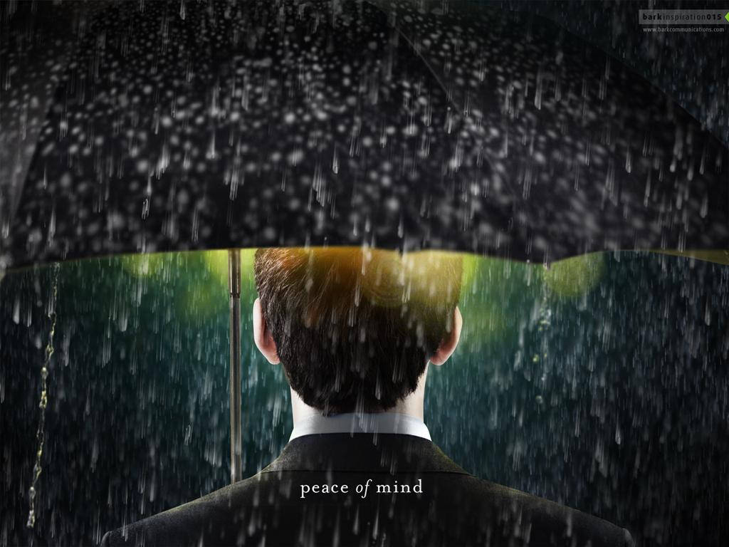 Umbrella 桌布 壁紙 — 一名身穿西裝的男子站在黑色雨傘下，雨水落在他周圍，溫暖的光芒在他頭後閃耀。