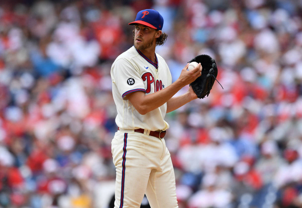 Phillies 桌布 壁紙 — 一名身穿費城人隊球衣的棒球投手，在模糊的球場人群背景下，專注地準備投球。