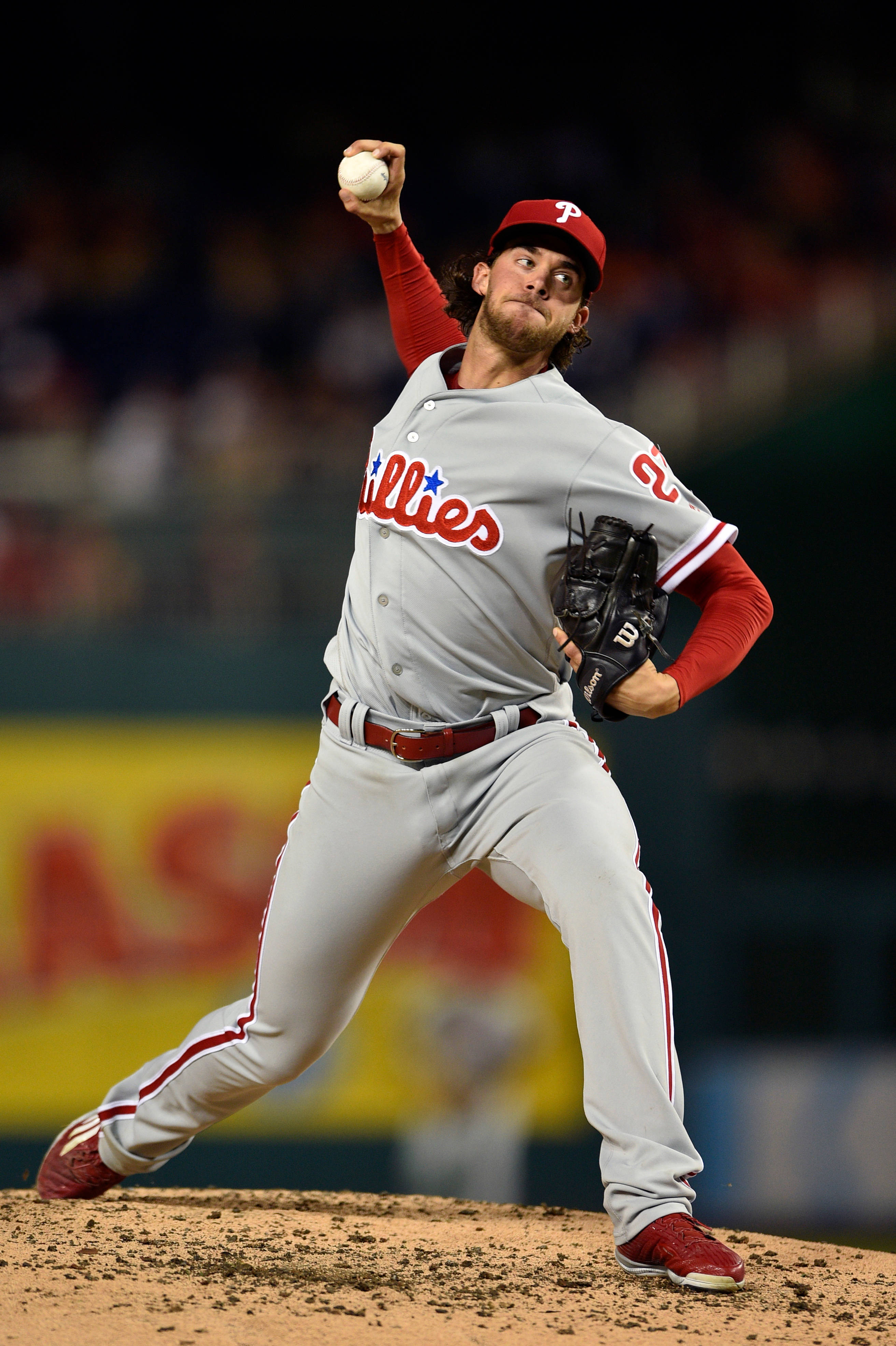 Phillies 桌布 壁紙 — 一名身穿費城人隊球衣的棒球投手在球場燈光下專注地投球。