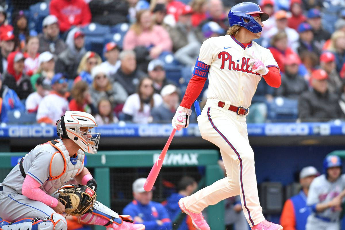Phillies 桌布 壁紙 — 一名身穿費城人隊球衣的棒球選手正在揮動粉紅色球棒，捕手蹲在他身後，球場內坐滿球迷。