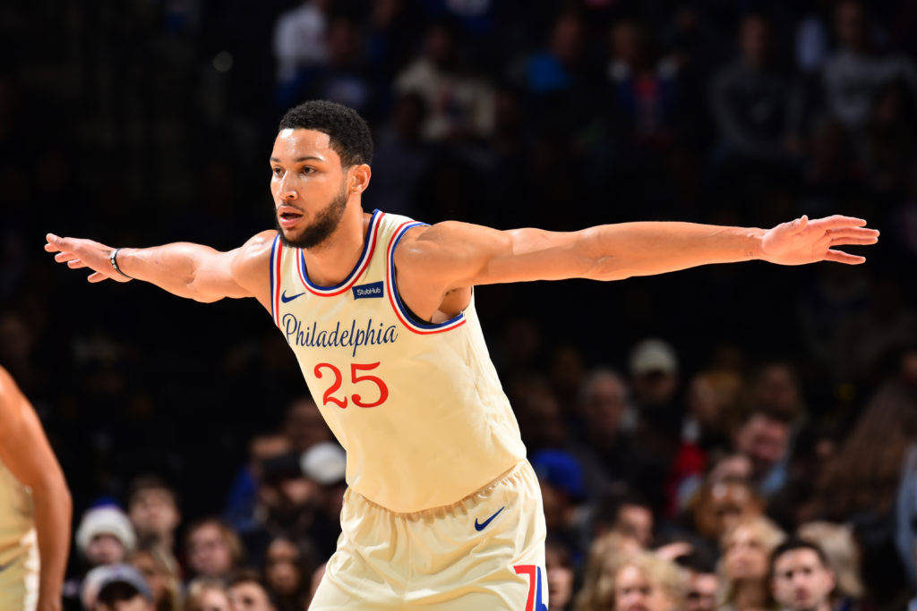 Ben Simmons 桌布 壁紙 — 一名身穿費城奶油色球衣、背號25的籃球運動員在明亮的場館燈光下比賽時張開雙臂。