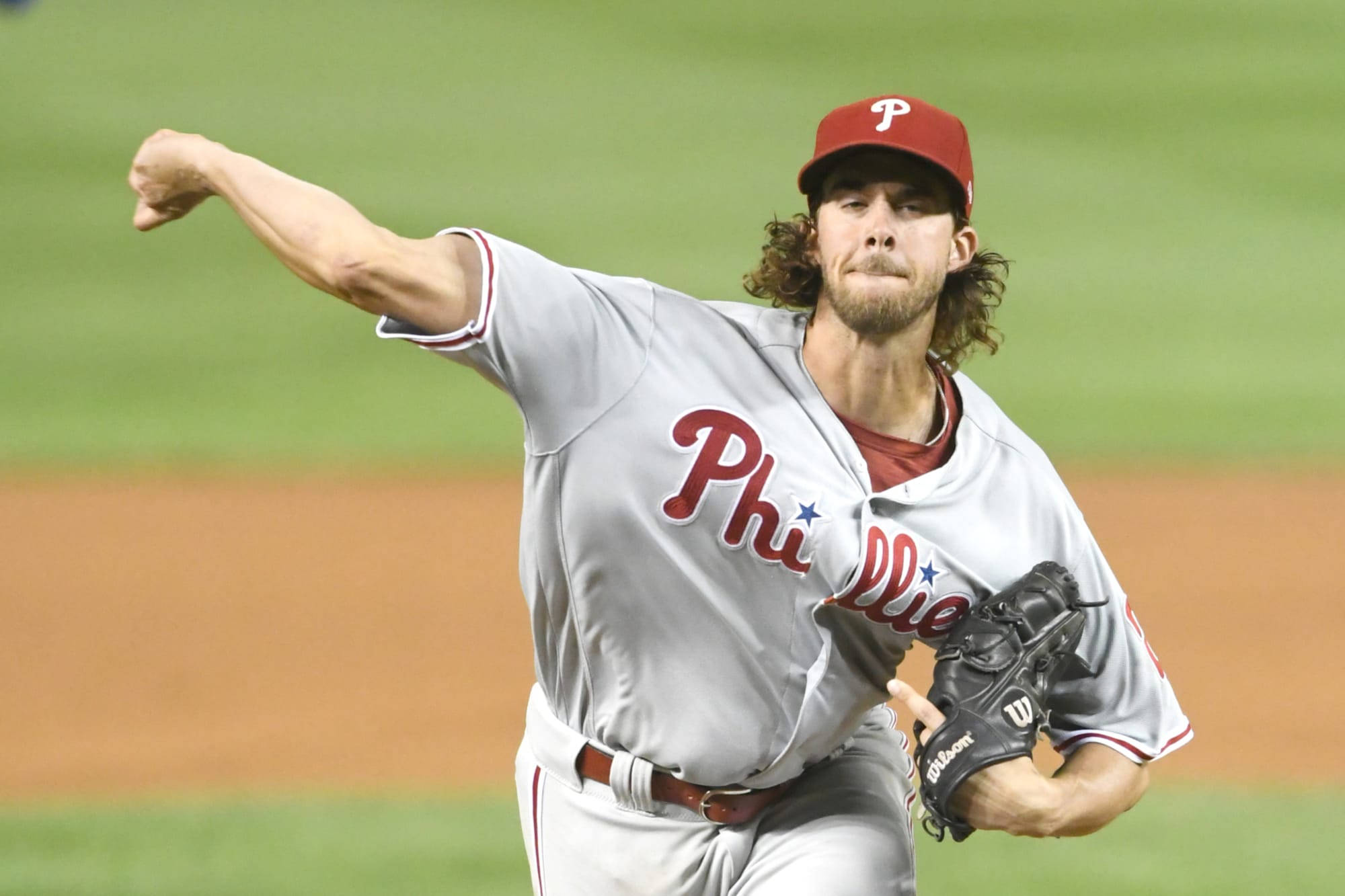 Phillies 桌布 壁紙 — 一名身穿費城費城人隊球衣的棒球投手在夜間燈光明亮的球場上投球。