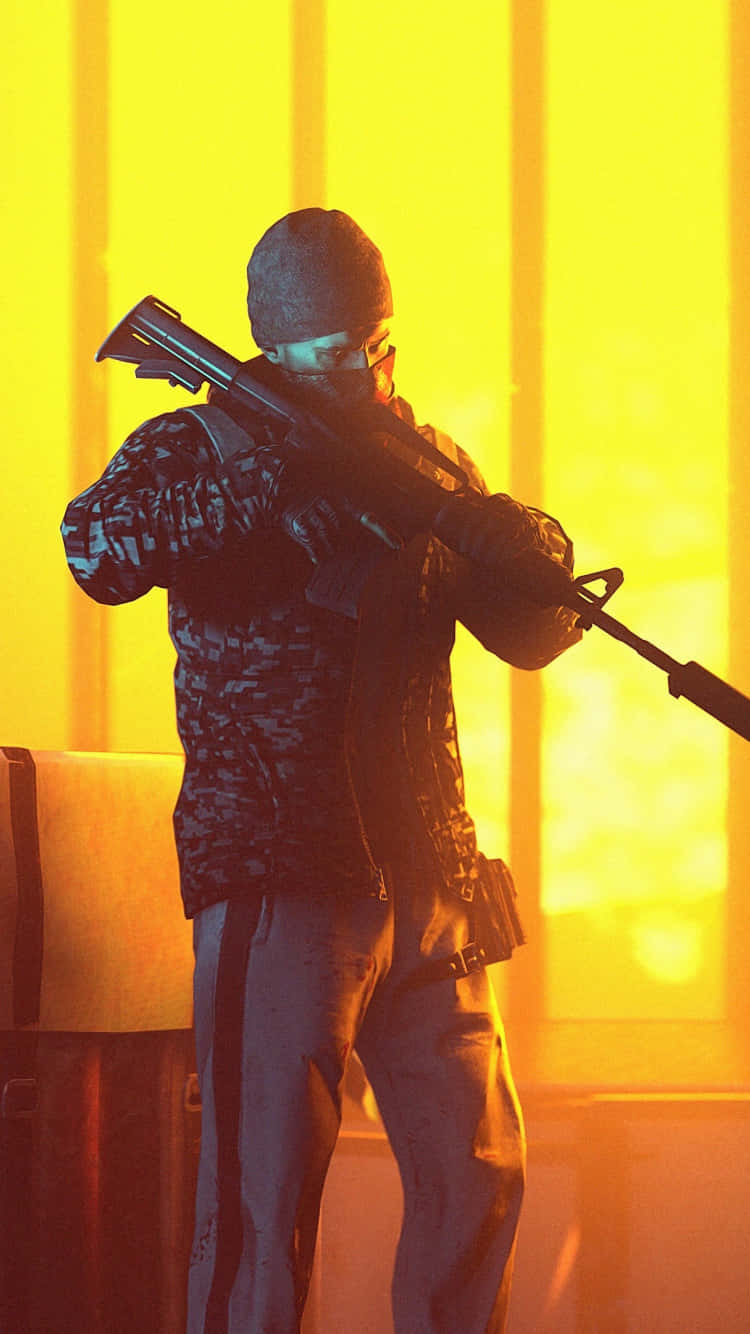 pubg mobile 桌布 壁紙 — 一名身穿迷彩服和毛帽的士兵，在發光的黃橙色背景下瞄準步槍。