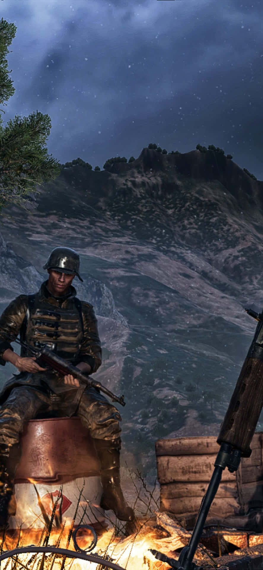 Battlefield V 桌布 壁紙 — 一名身穿迷彩服的士兵在夜晚坐在營火旁，背景是星空下的山脈。