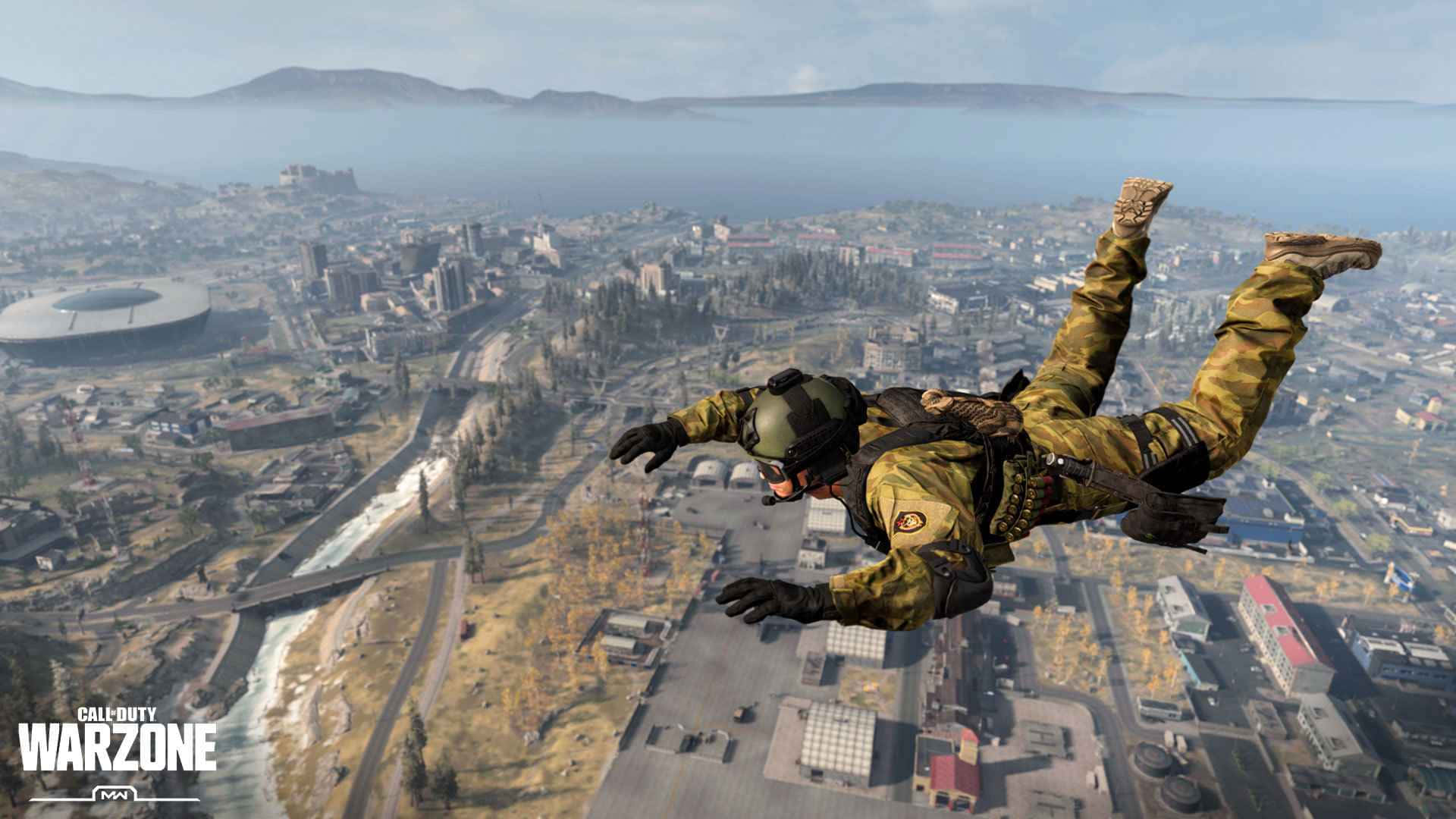 Call Of Duty Battles 桌布 壁紙 — 一名身穿迷彩服的士兵在廣闊的城市景觀上空跳傘，遠處有山脈和水域。