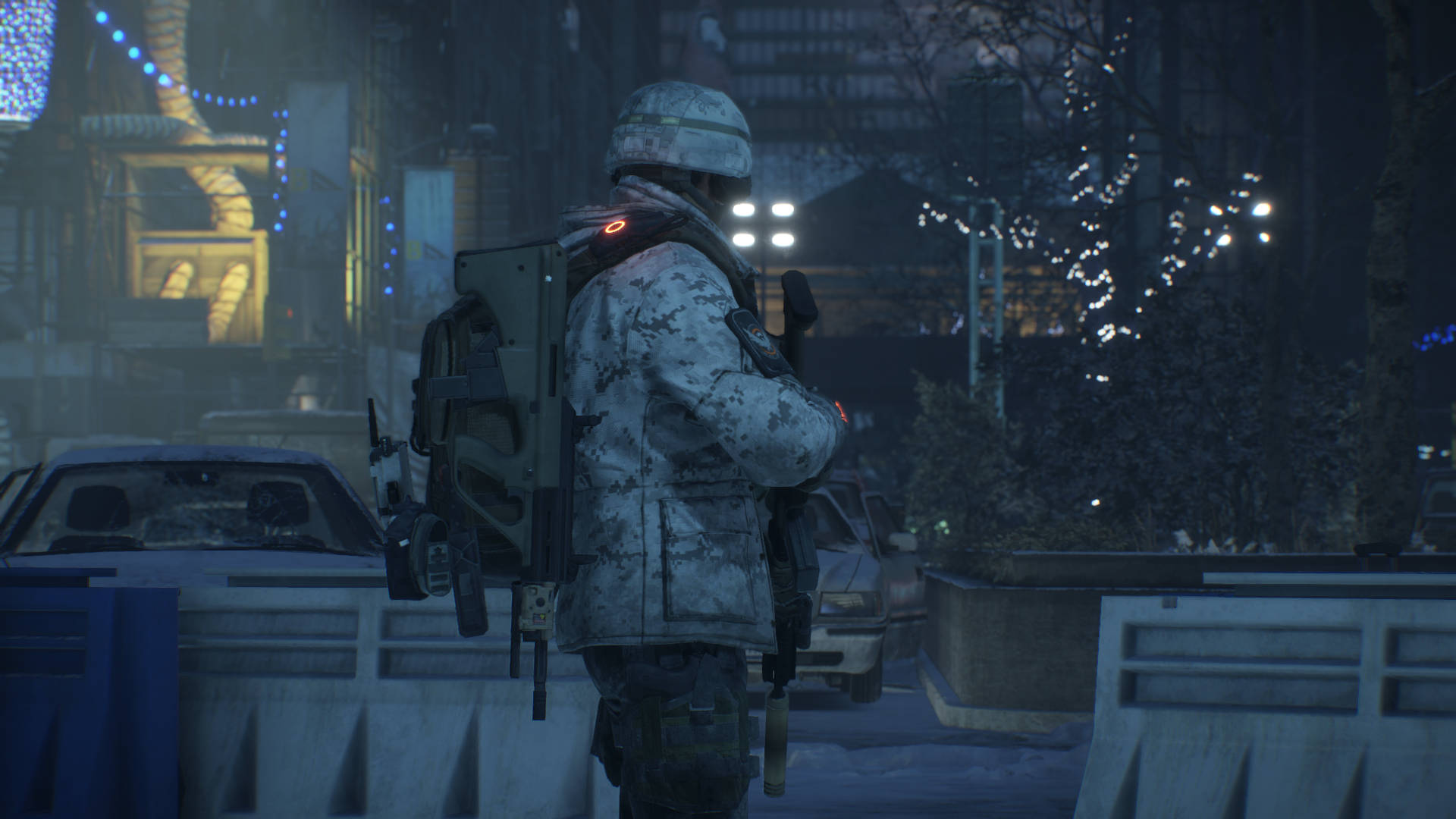 Division 桌布 壁紙 — 一名身穿迷彩裝備的士兵在夜間於積雪的城市街道上保持警覺，周圍有節日燈飾和路障。