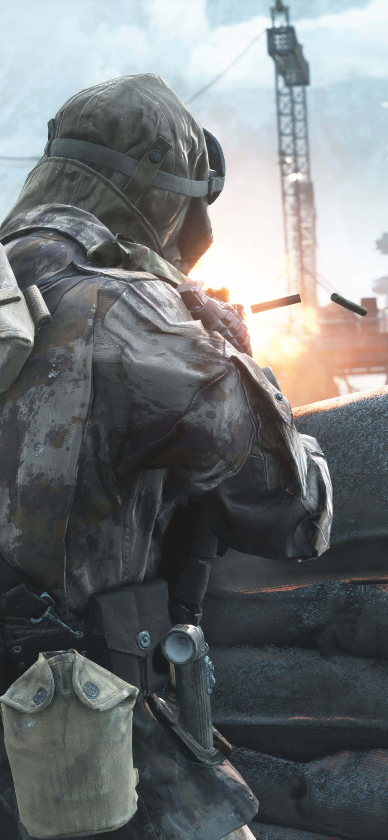 battlefield v iPhone 桌布 壁紙 — 一名身穿迷彩裝備的士兵在沙袋屏障後方開火，槍口閃光映照出戰火摧殘的工業背景。