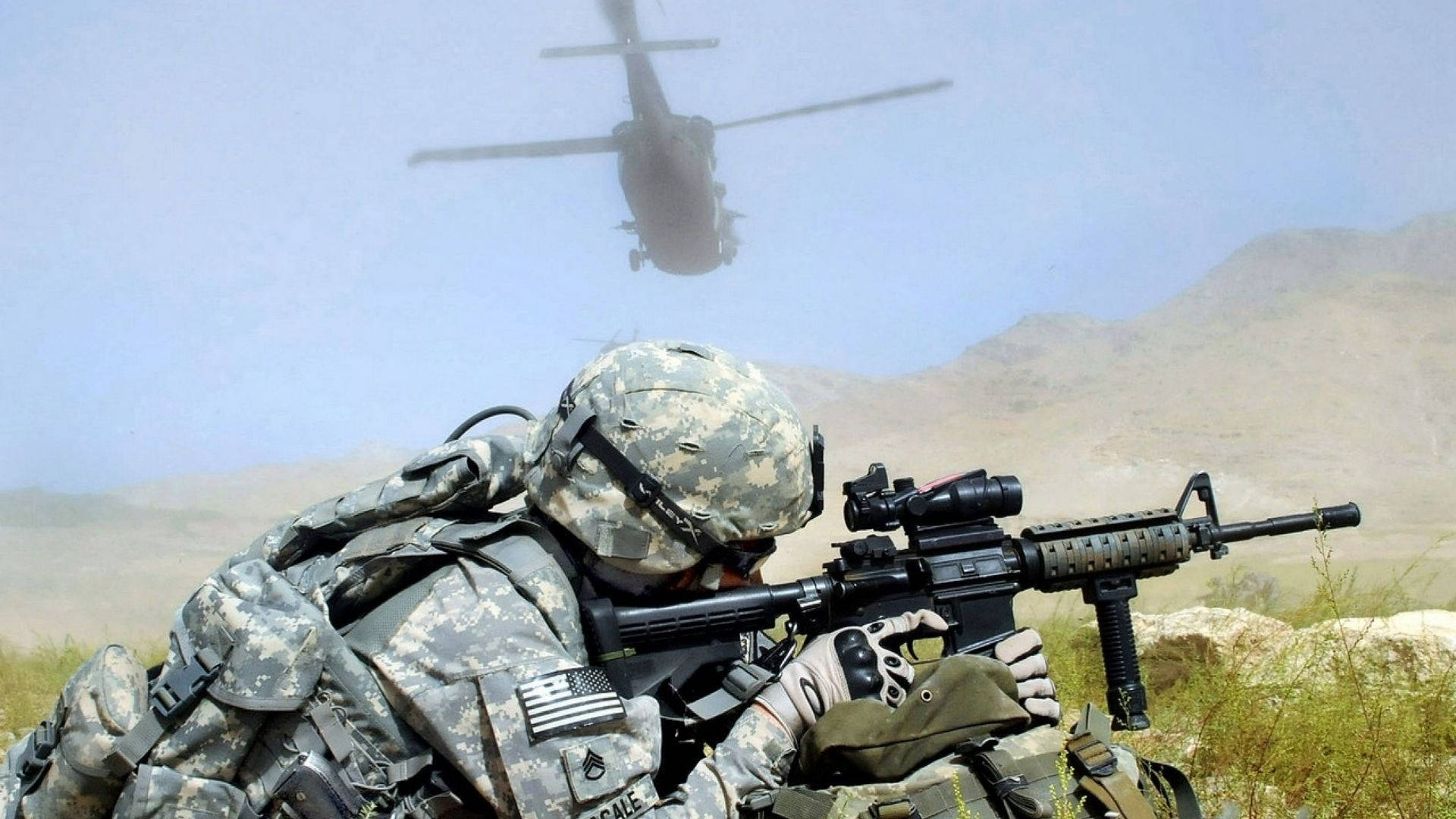 士兵用步槍瞄準，直升機在沙漠山脈上空飛過。