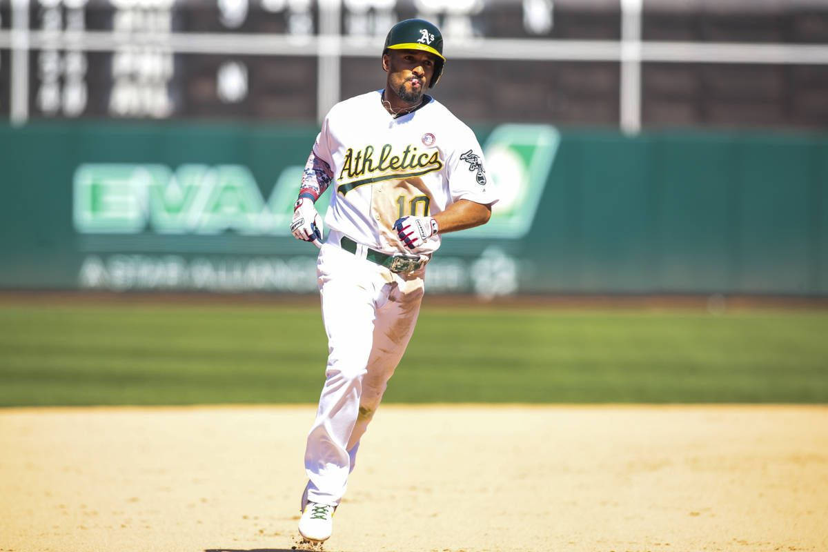 Oakland Athletics 桌布 壁紙 — 一名身穿運動家隊球衣的棒球選手，帶著專注的決心在陽光明媚的球場上衝刺。