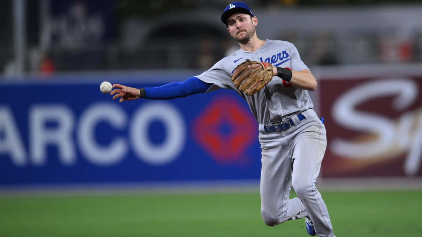 Trea Turner Phillies 桌布 壁紙 — 一名身穿道奇隊球衣的棒球運動員在夜間比賽中於球場燈光下投擲棒球。