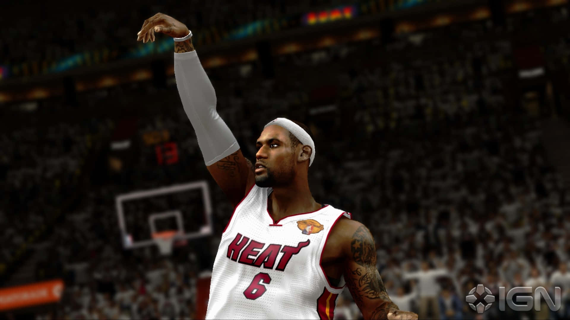 NBA 2k 桌布 壁紙 — 一名身穿邁阿密熱火球衣的籃球運動員在擠滿觀眾的場館中比賽時勝利地舉起手臂。