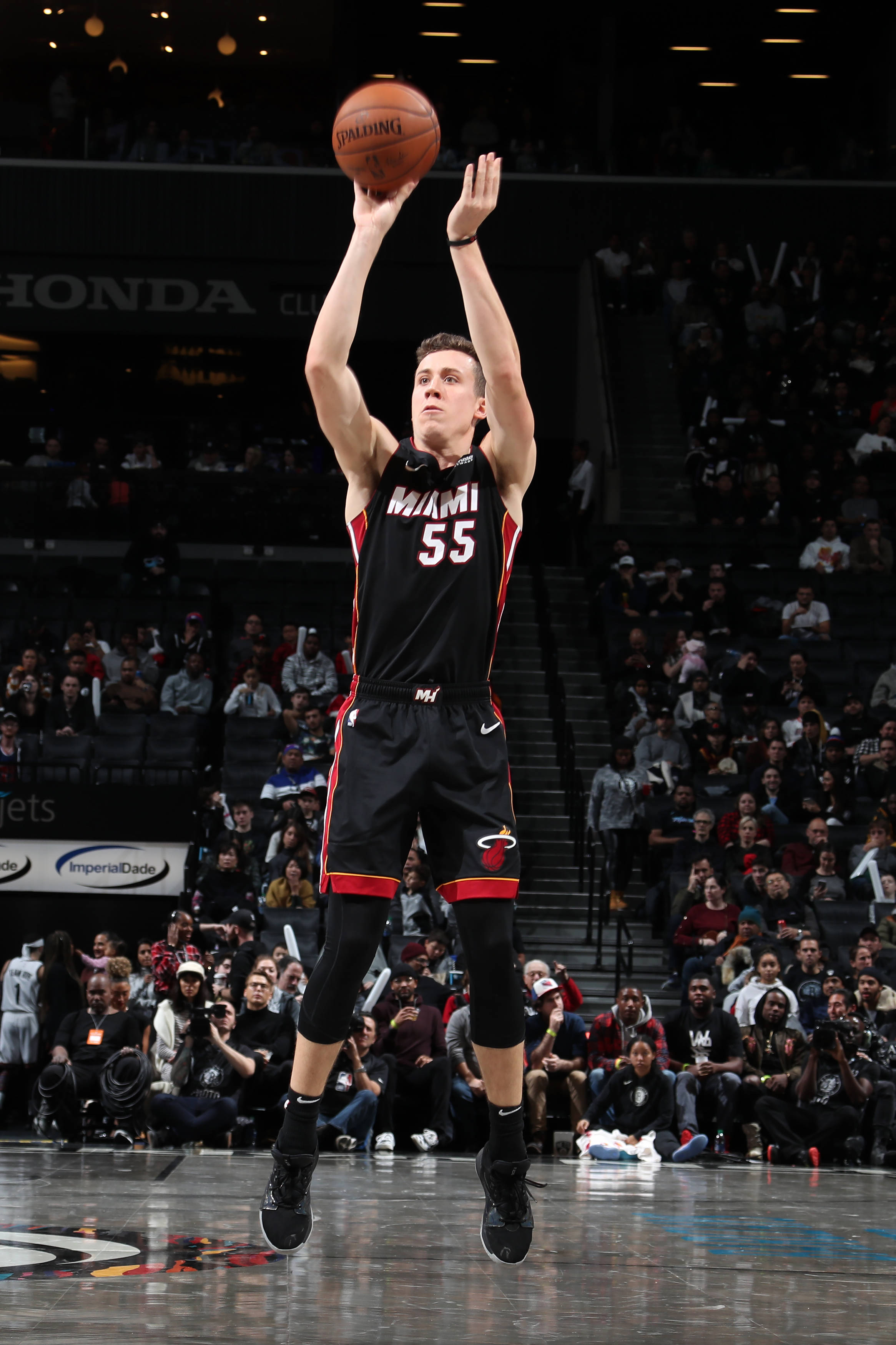 duncan robinson 桌布 壁紙 — 一名身穿邁阿密熱火球衣的籃球運動員在比賽中高高躍起投籃，下方有觀眾觀看。