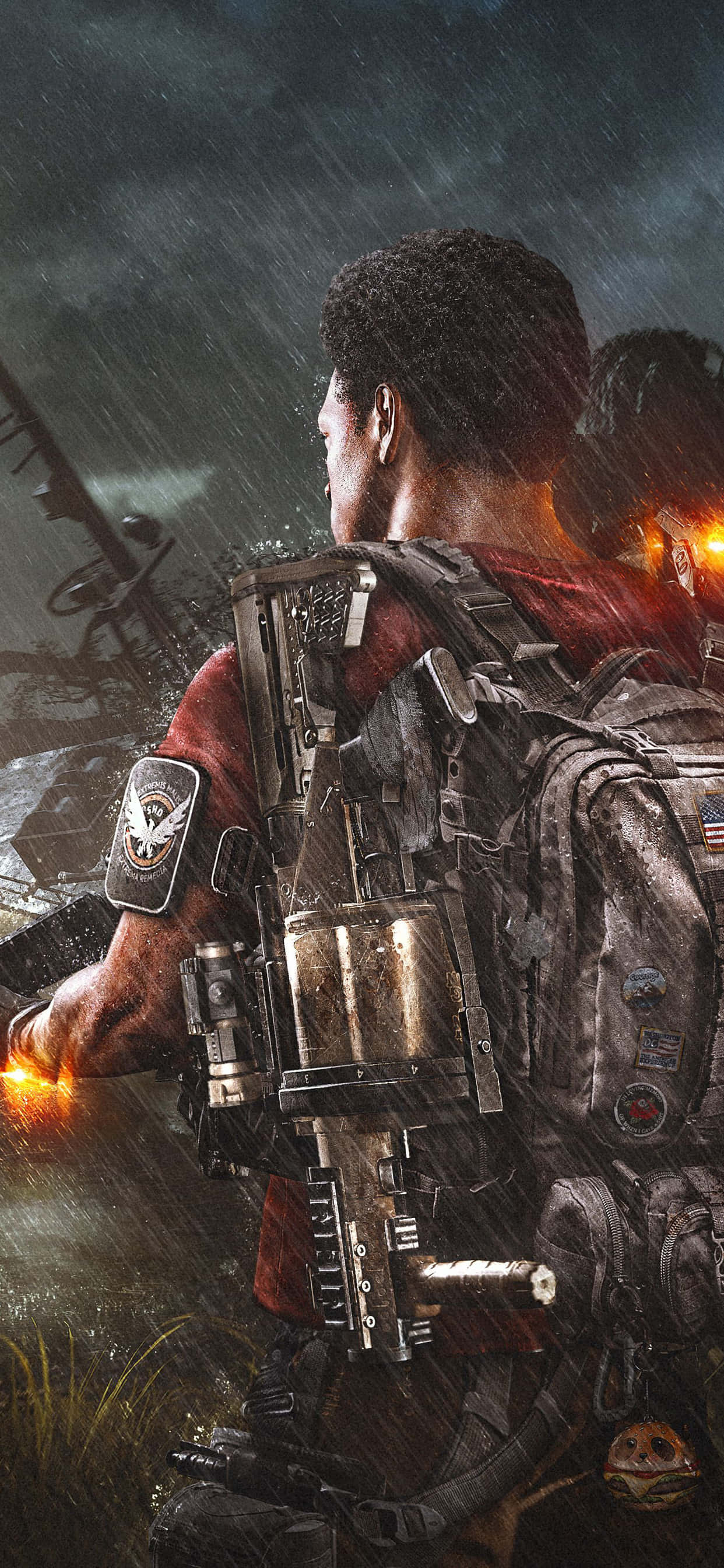 iPhone Xs Max The Division 桌布 壁紙 — 一名身穿重型裝備的士兵在暴風雨的天空下站在雨中，身後有遠處的火光和殘骸。