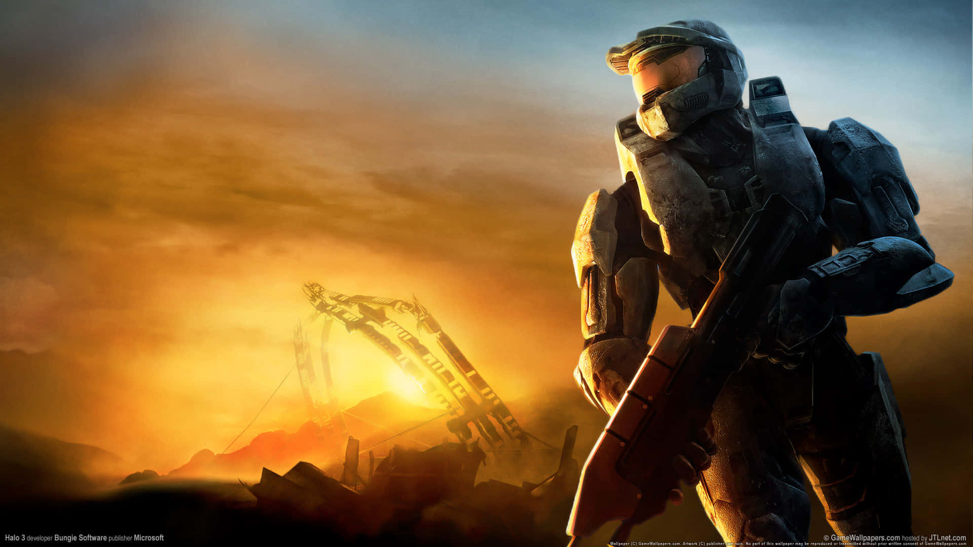 Master Chief 桌布 壁紙 — 一名身穿重甲的斯巴達戰士，在戰火摧殘的戰場上，以燃燒的夕陽和一輛墜毀的車輛為背景，形成剪影。