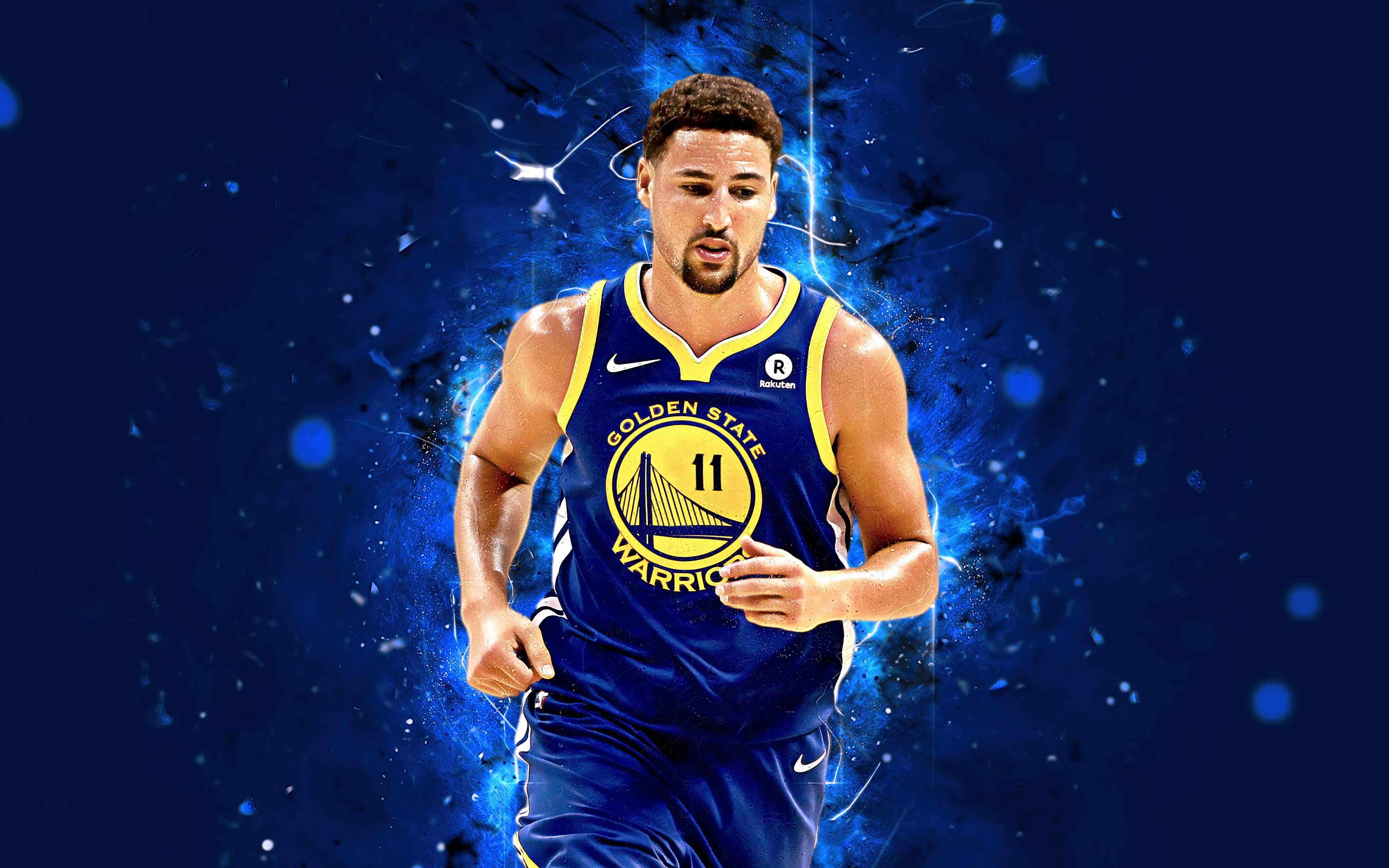 Klay Thompson 桌布 壁紙 — 一名身穿金州勇士隊球衣的籃球運動員向前奔跑，周圍有電藍色能量粒子在深藍色背景上爆發。
