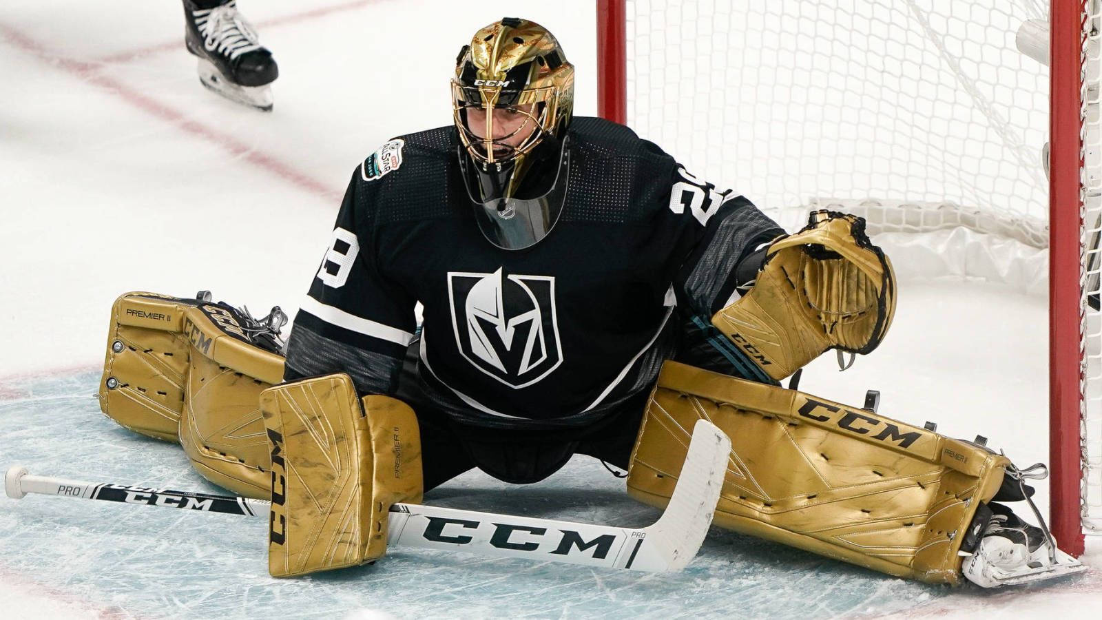 hockey 桌布 壁紙 — 一名身穿金色和黑色裝備的冰球守門員在比賽期間蹲在球門附近的冰面上。