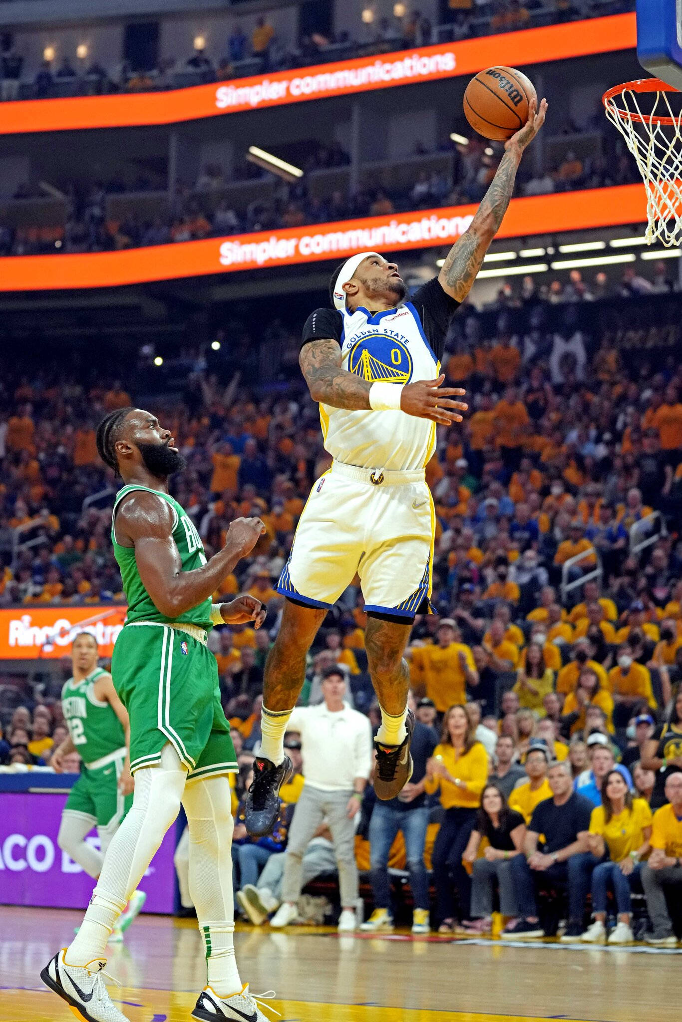 NBA 桌布 壁紙 — 一名身穿金色球衣的籃球運動員高高躍起準備灌籃，而身穿綠色球衣的防守球員在明亮的場館燈光下專注地注視著。