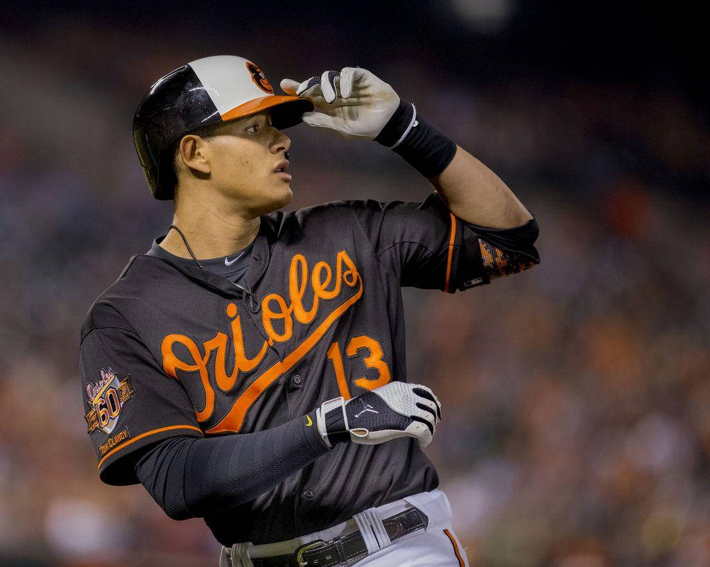 Machado 桌布 壁紙 — 一名身穿金鶯隊球衣的棒球選手在夜間比賽中於球場燈光下調整帽子。