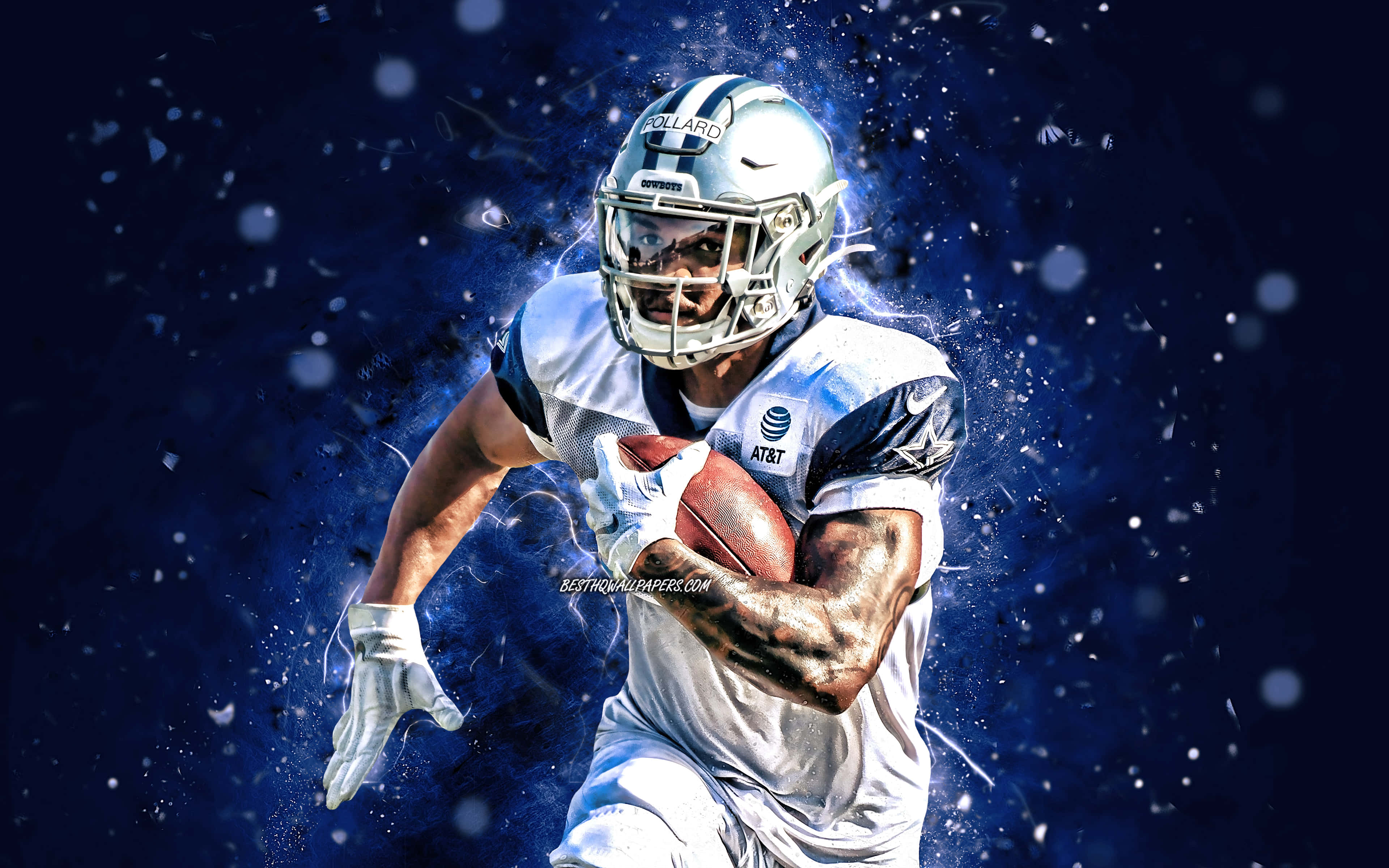 Dallas Cowboys Players 桌布 壁紙 — 一名身穿銀色頭盔和白色球衣的美式足球運動員，在動態藍色粒子背景前，抱著橄欖球向前衝刺。