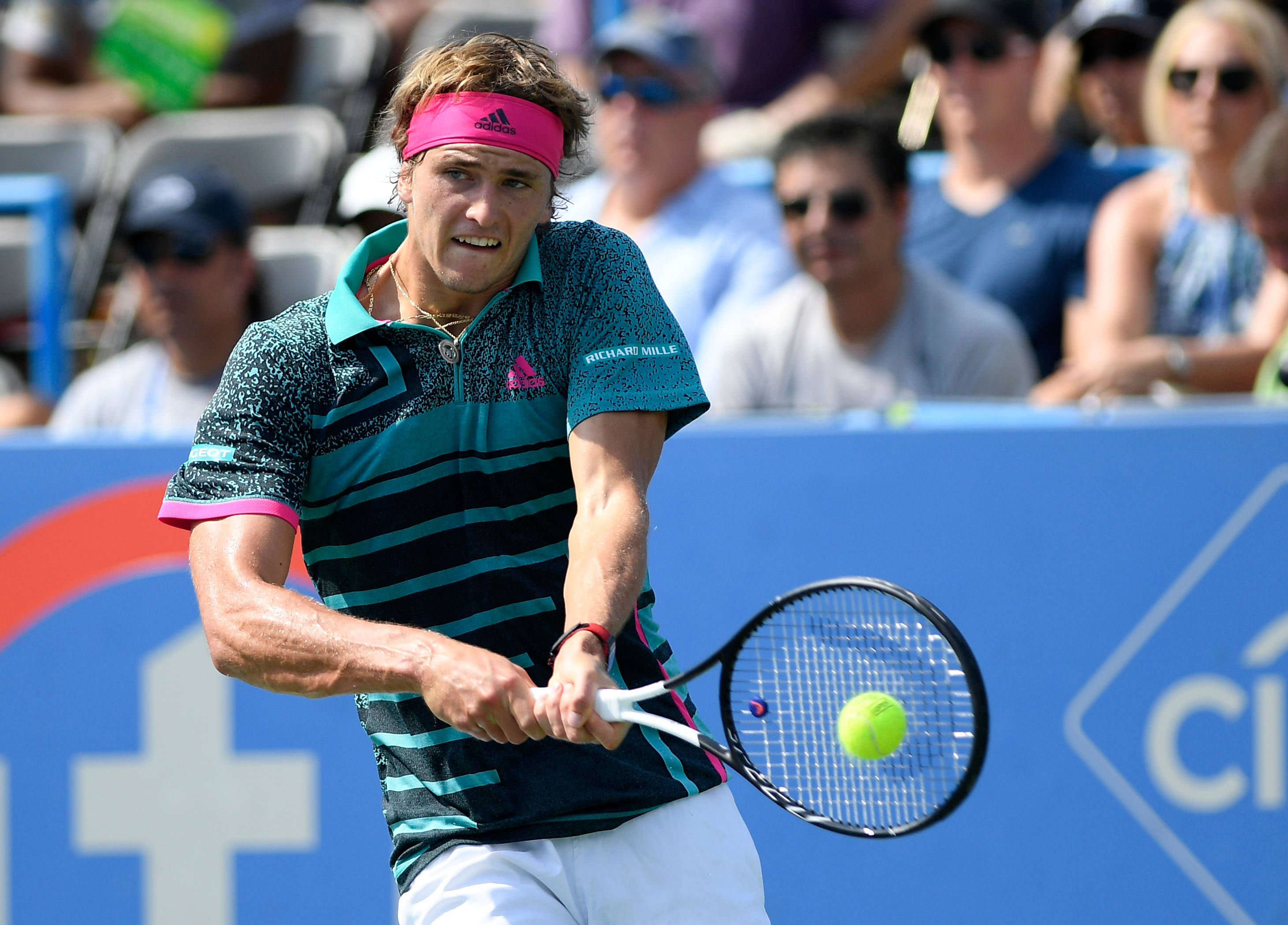 alexander zverev 桌布 壁紙 — 一名身穿青綠色和黑色條紋襯衫的男網球選手在比賽中揮拍擊打亮黃色的網球。