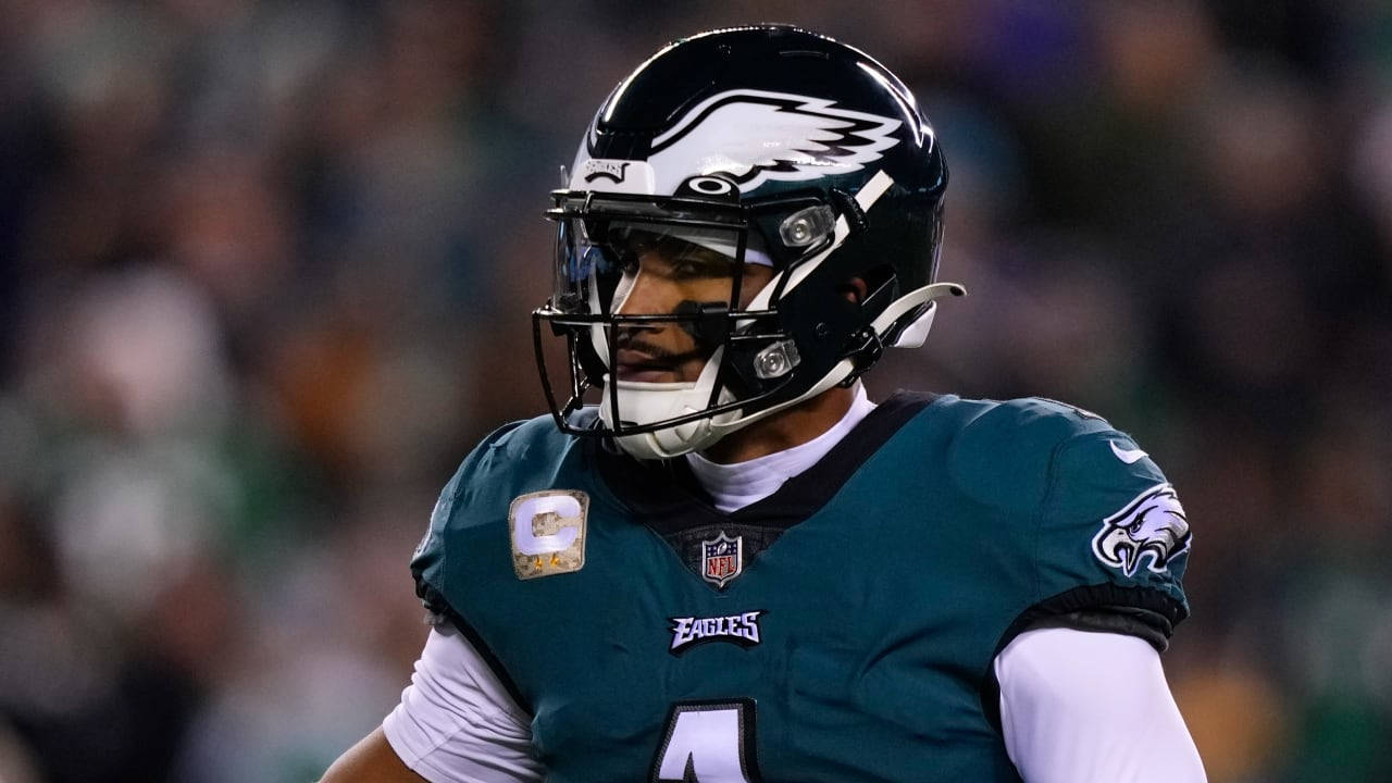 NFL 桌布 壁紙 — 一名身穿青綠色球衣和頭盔的費城老鷹隊美式足球員在球場燈光下專注地站在場上。