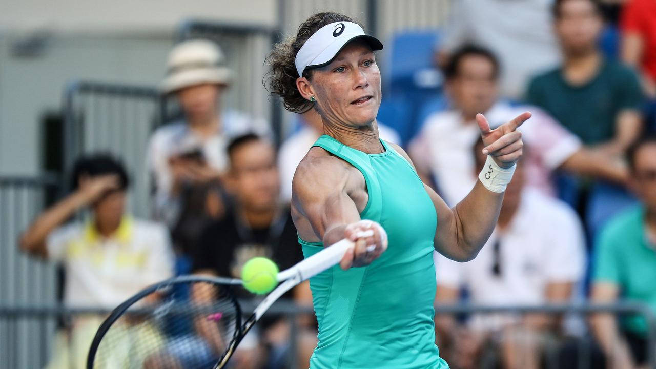 Tennis 桌布 壁紙 — 一名身穿青綠色球衣的女網球選手在比賽中揮拍擊打亮黃色的球，背景有模糊的觀眾。