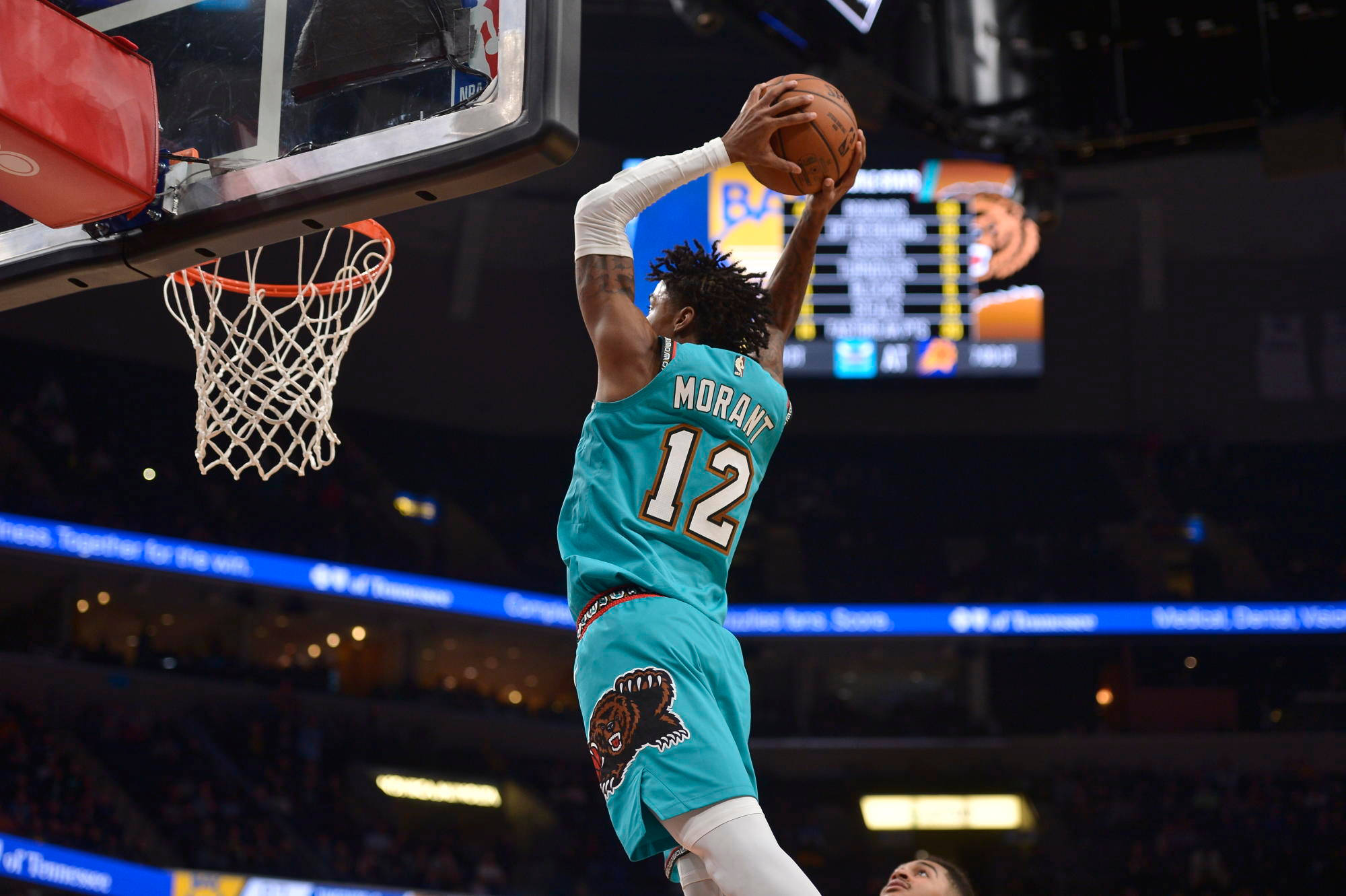 NBA 桌布 壁紙 — 一名身穿青綠色球衣的籃球運動員在明亮的場館燈光下，專注地灌籃。