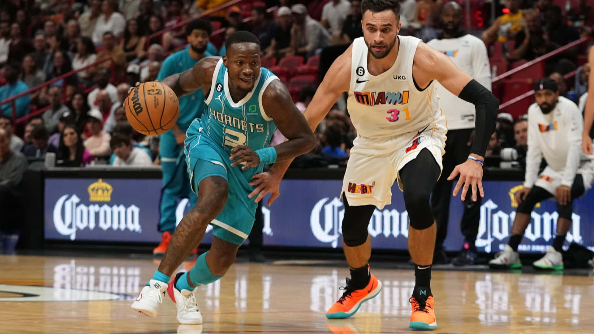 NBA 桌布 壁紙 — 一名身穿青綠色球衣的籃球運動員在場館燈光下的一場激烈比賽中，運球越過一名身穿白色球衣的防守球員。
