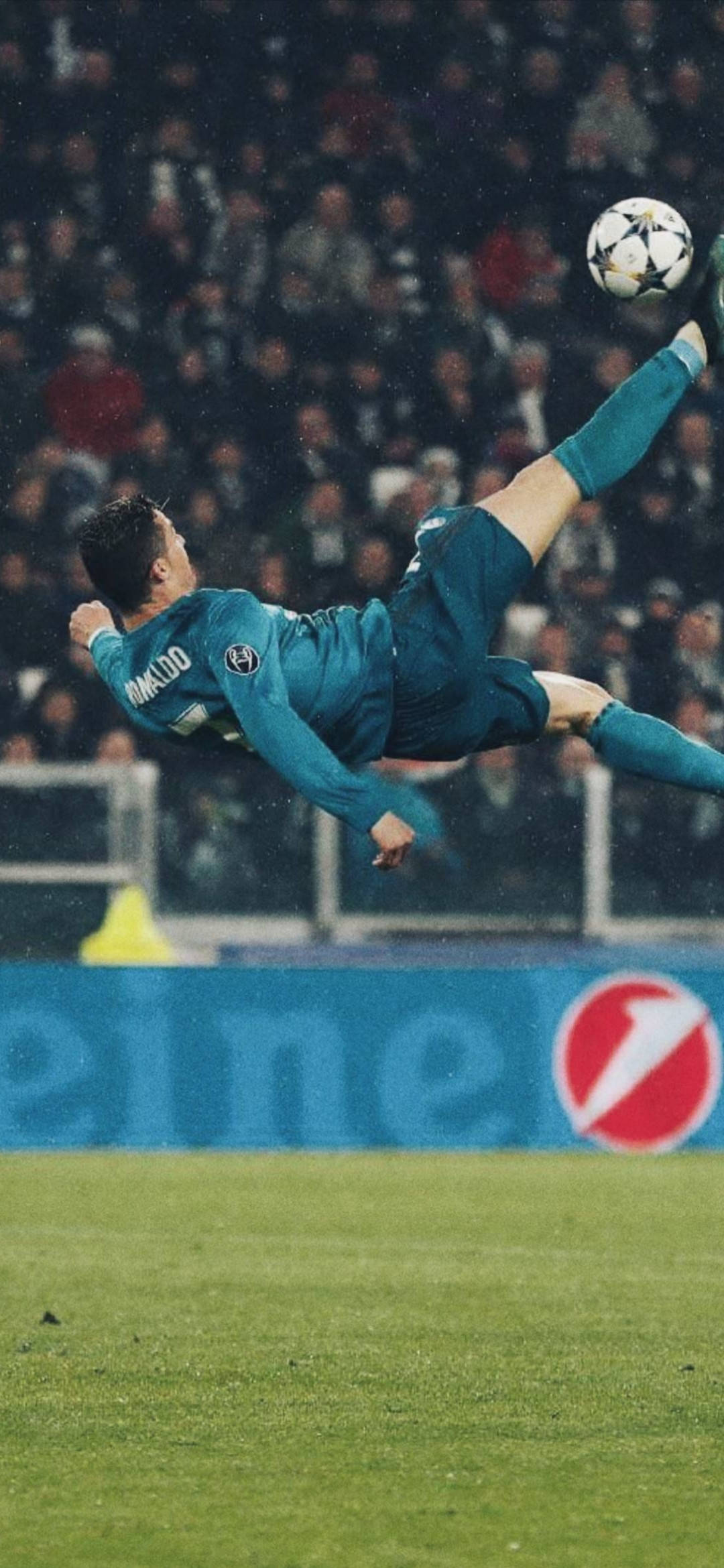 Ronaldo 桌布 壁紙 — 一名身穿青綠色球衣的足球運動員在球場燈光下，於濕滑的雨地球場上表演雜技式倒掛金鉤。