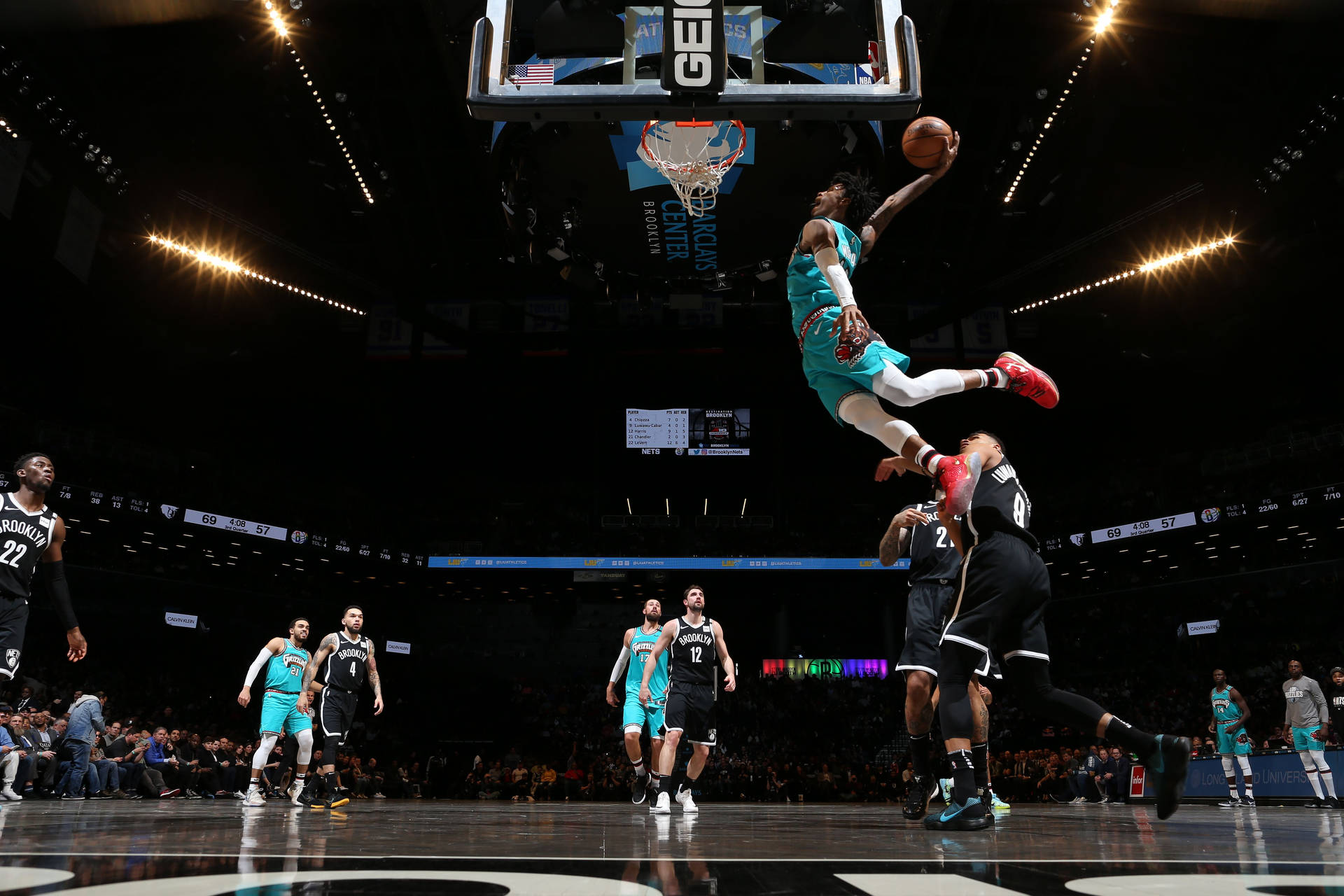 籃球運動員在空中隔著防守球員灌籃。 — Ja Morant 動圖 壁紙