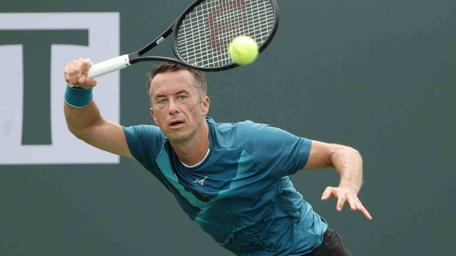 Tennis 桌布 壁紙 — 一名身穿青綠色襯衫的男性網球運動員在比賽中揮動球拍擊打明亮的黃色網球。