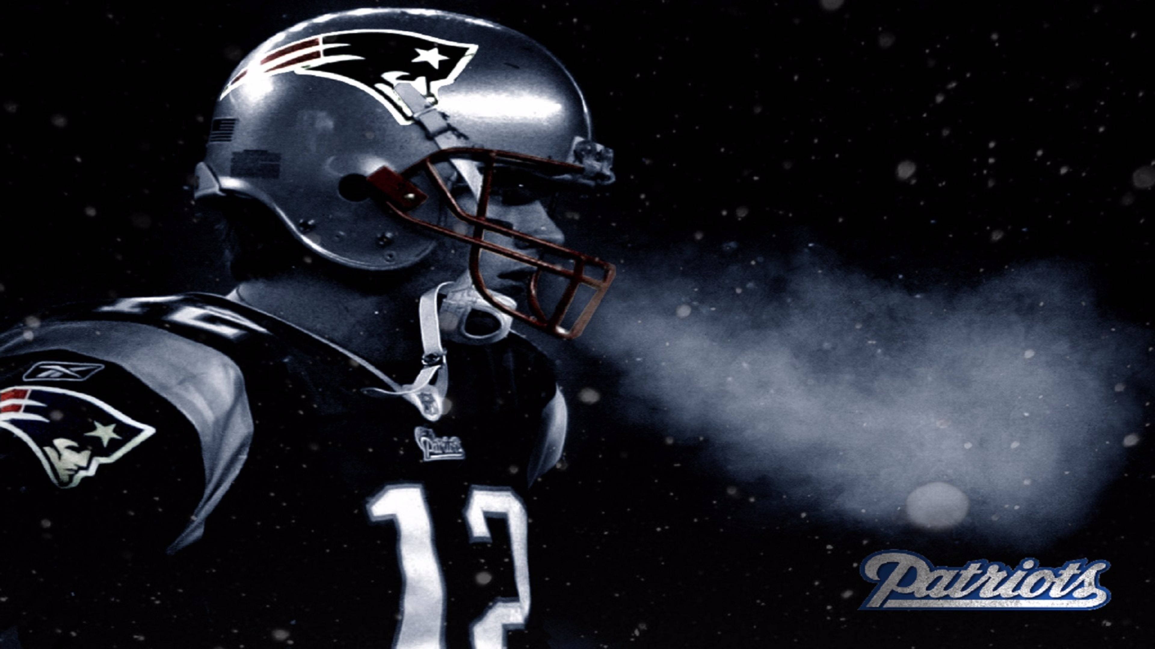Patriots 桌布 壁紙 — 一名身穿頭盔和球衣的新英格蘭愛國者美式足球員在雪夜黑暗背景下呼出霧氣。
