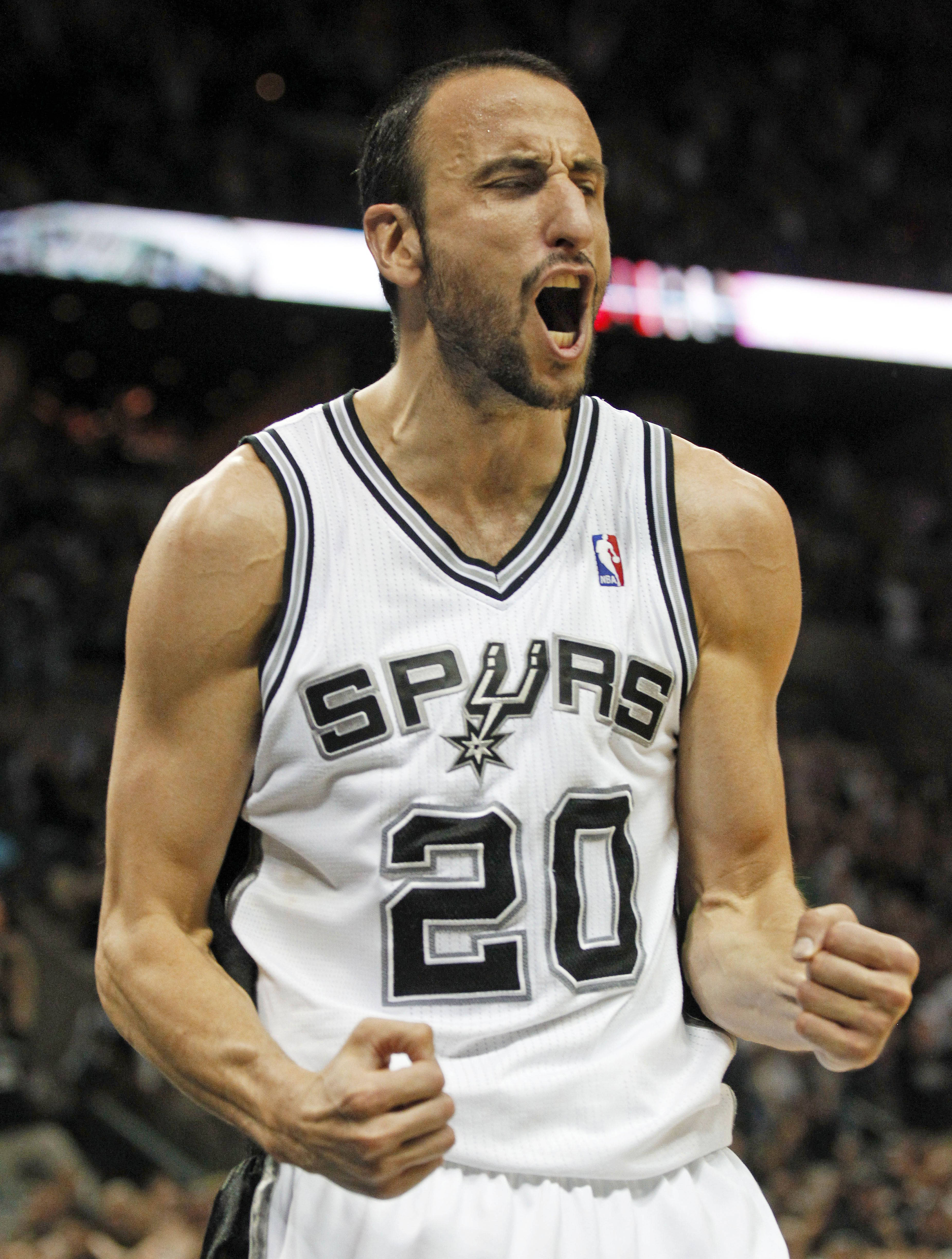 Manu 桌布 壁紙 — 一名身穿馬刺隊球衣的籃球運動員在場館燈光下激烈的比賽中握緊拳頭怒吼。