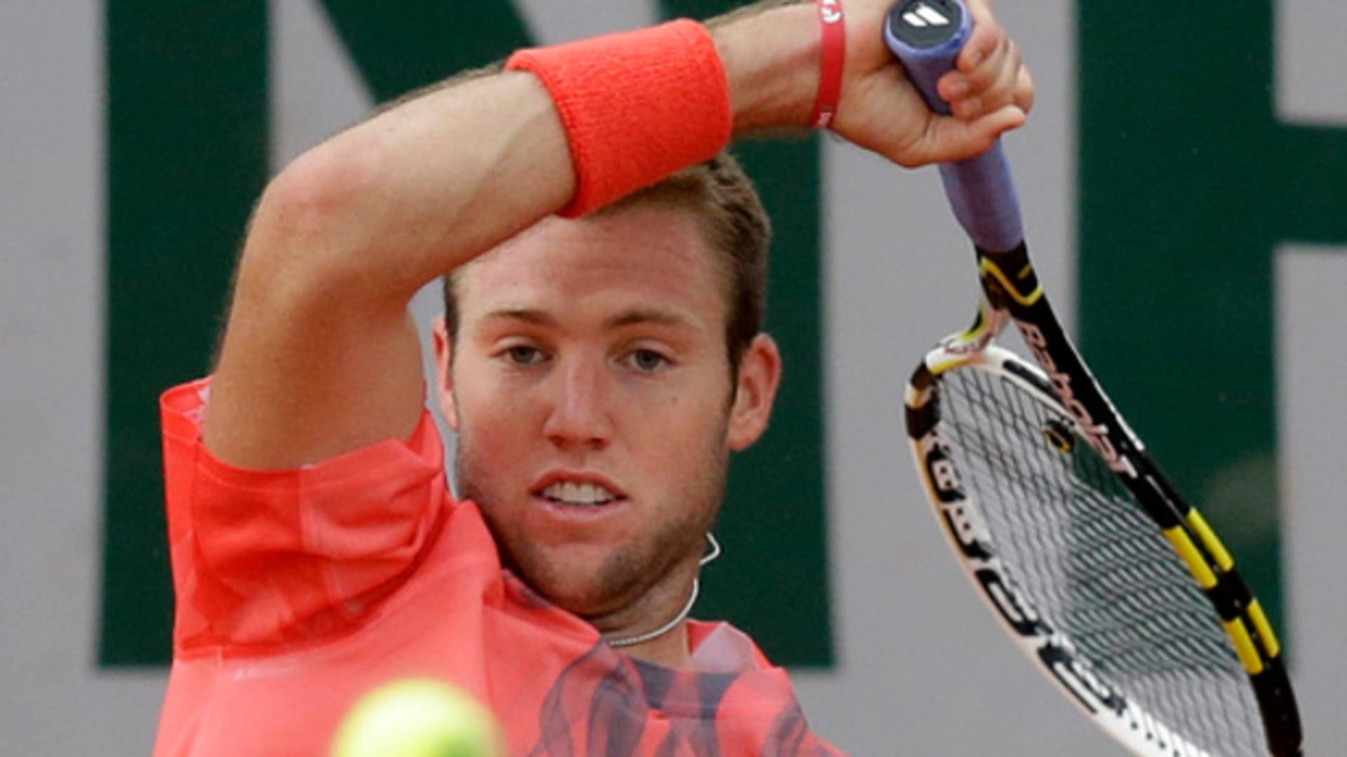 Tennis 桌布 壁紙 — 一名身穿鮮橙色襯衫的男網球運動員正準備以高度專注力擊打黃色網球。
