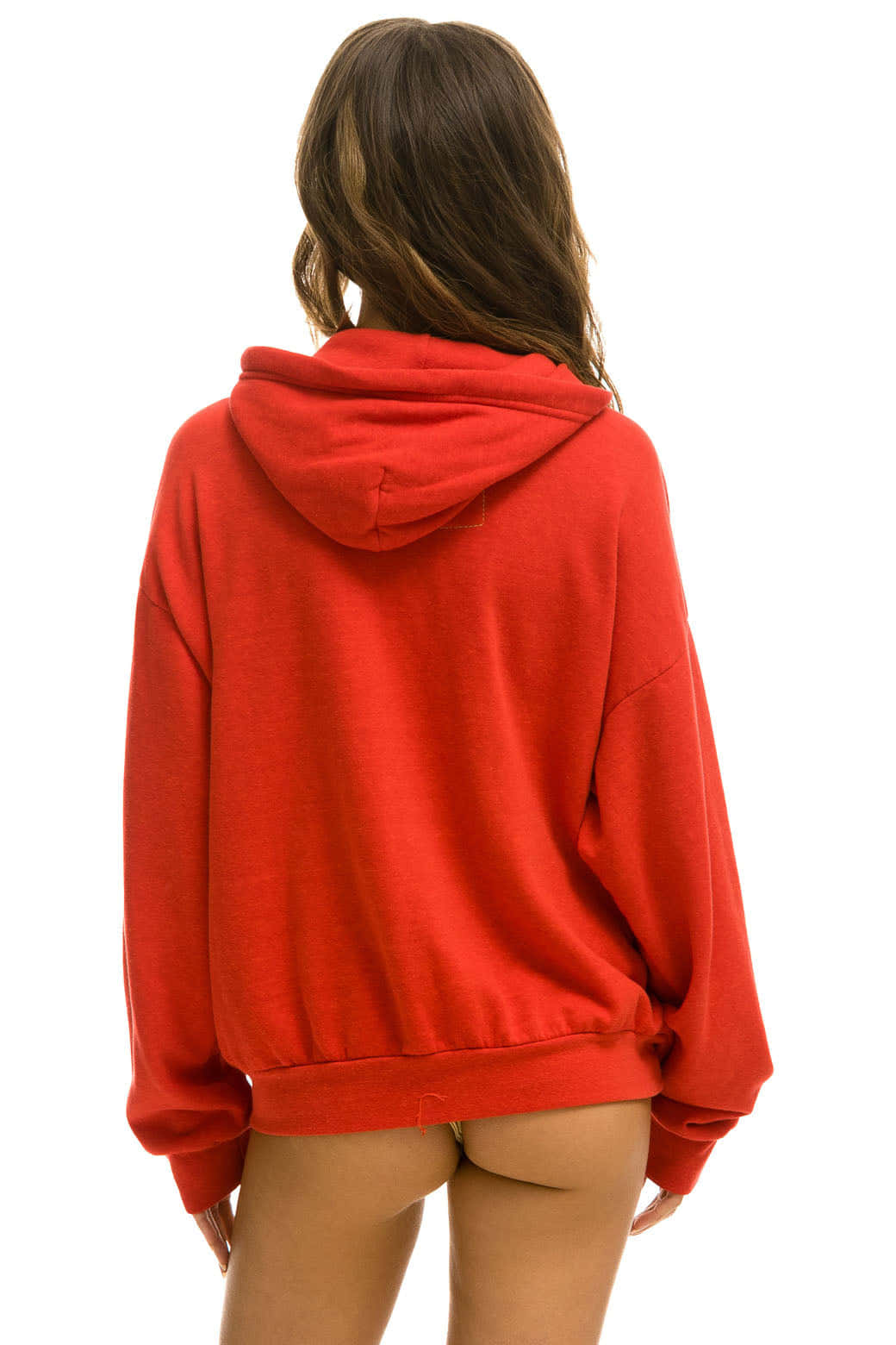 Red Hoodie 桌布 壁紙 — 一名身穿鮮紅色超大連帽衫的女性背對相機，站在純白色背景前。