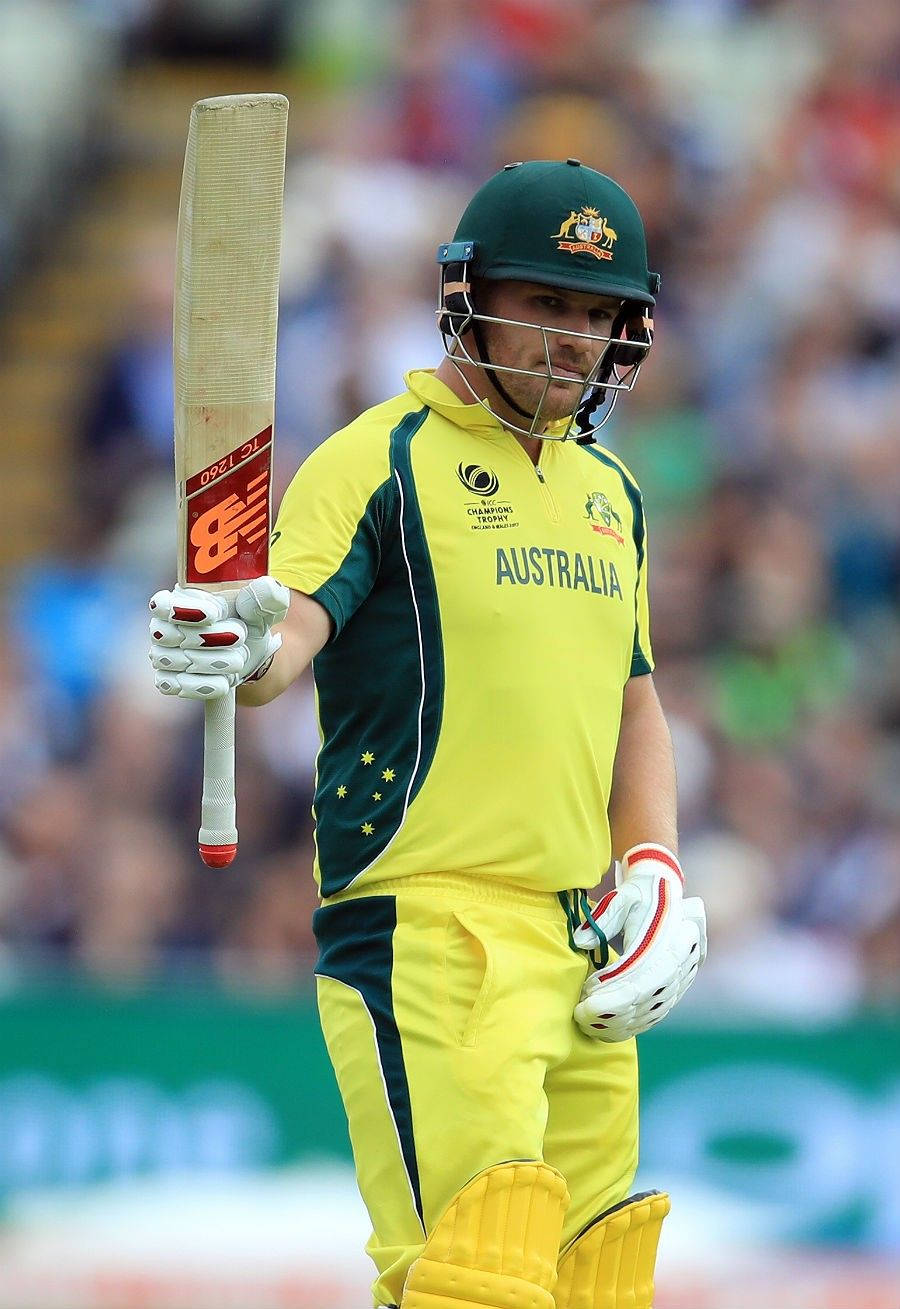 Aaron Finch 桌布 壁紙 — 一名身穿黃綠色球衣的澳洲板球運動員在比賽中專注地握著球棒。