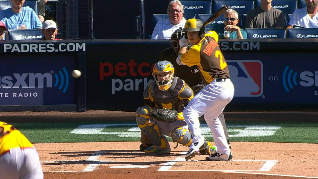 Bregman 桌布 壁紙 — 一名身穿黃色和棕色球衣的棒球打擊手在明亮的球場燈光下揮棒，捕手蹲伏在本壘板後方。