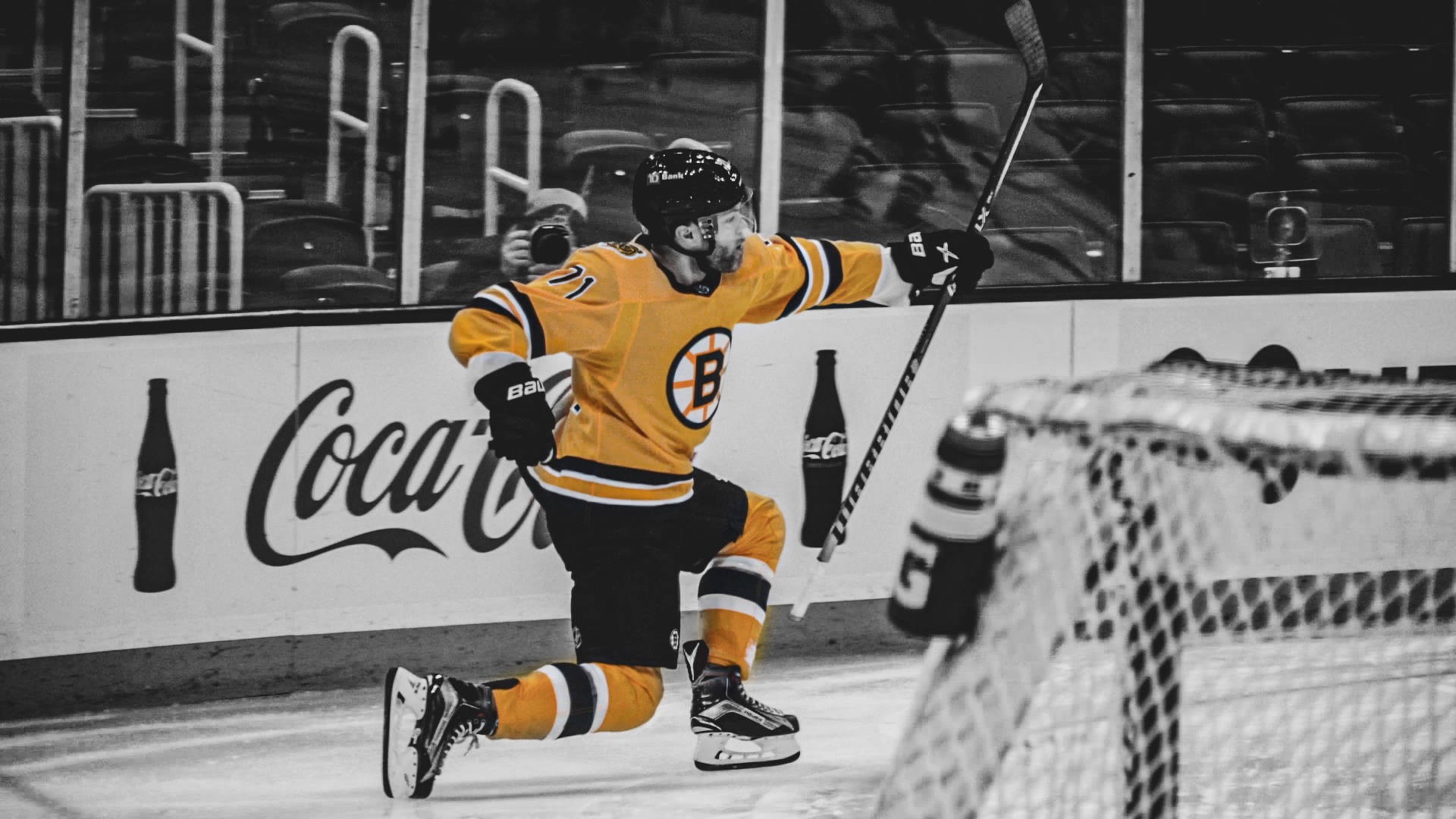 hockey 桌布 壁紙 — 一名身穿黃色波士頓棕熊隊球衣的冰球運動員在黑白背景的冰上慶祝進球。
