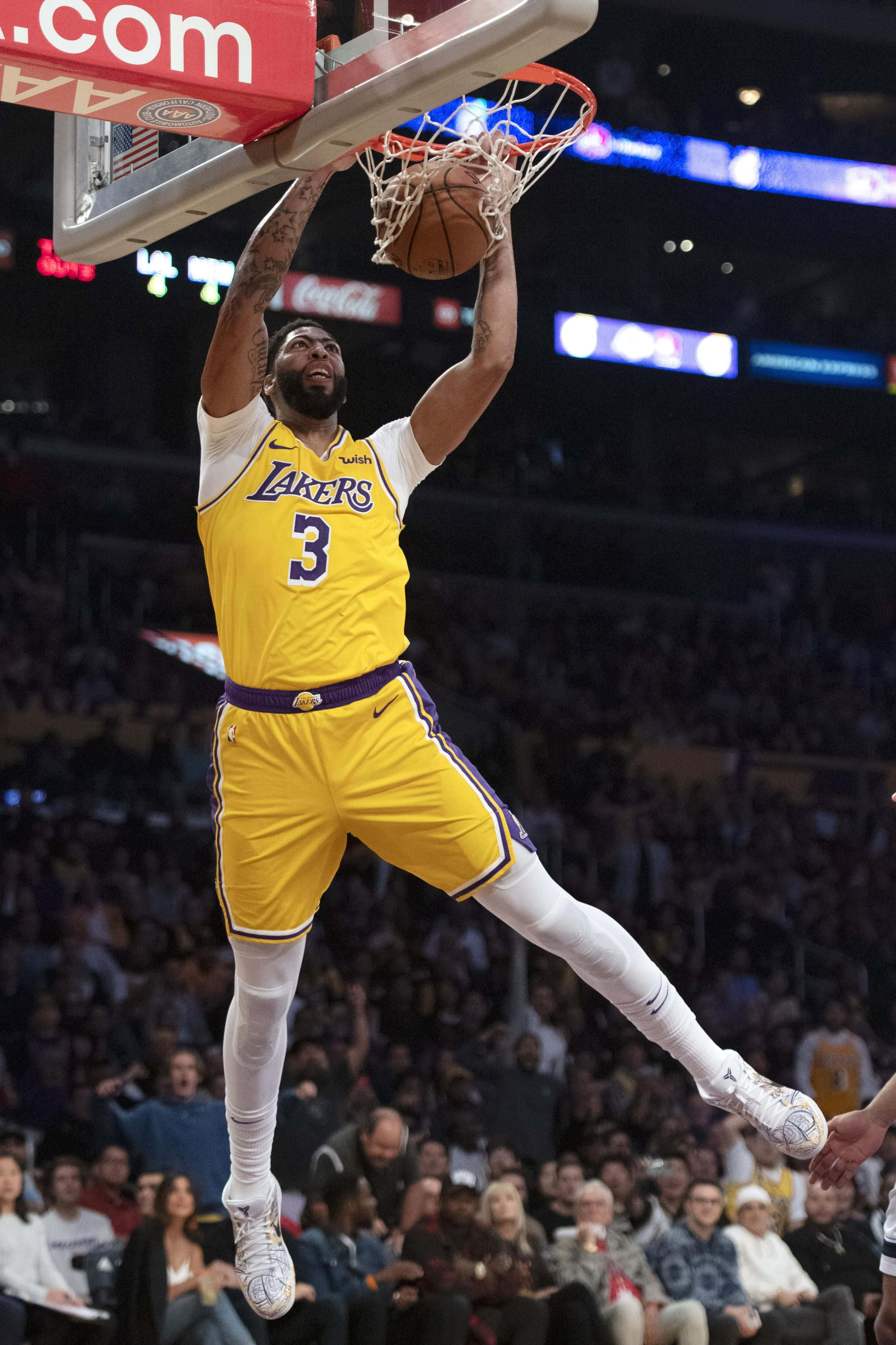 Anthony Davis 桌布 壁紙 — 一名身穿黃色湖人球衣的籃球運動員在明亮的場館燈光下，於比賽中強力灌籃。