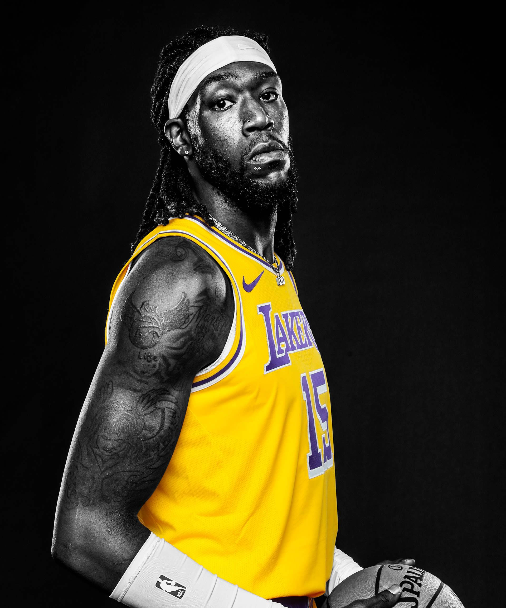 montrezl harrell 桌布 壁紙 — 一名身穿黃色湖人球衣的籃球運動員，在強烈的黑色背景下，戲劇性的燈光中手持籃球。